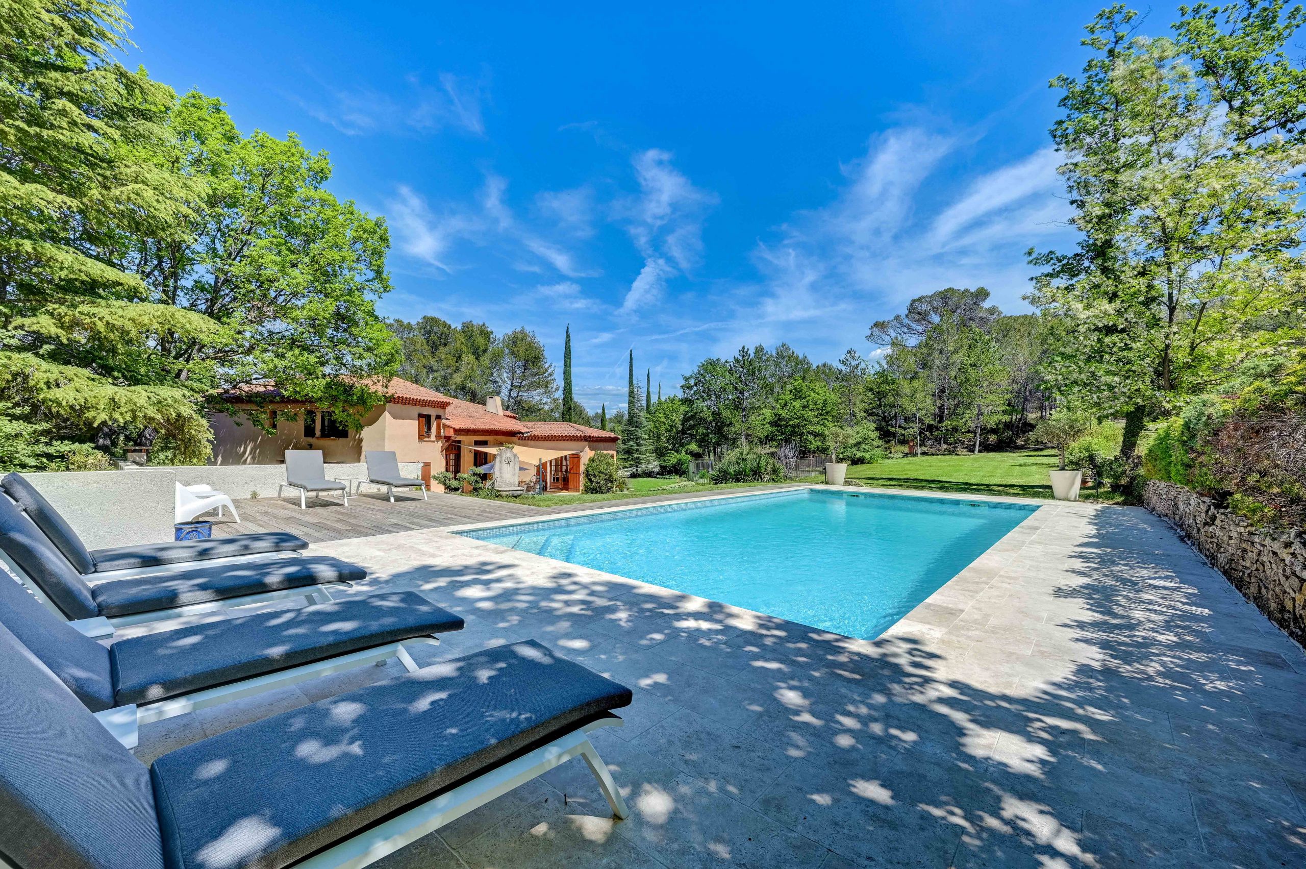 a pool with lounge chairs and a pool