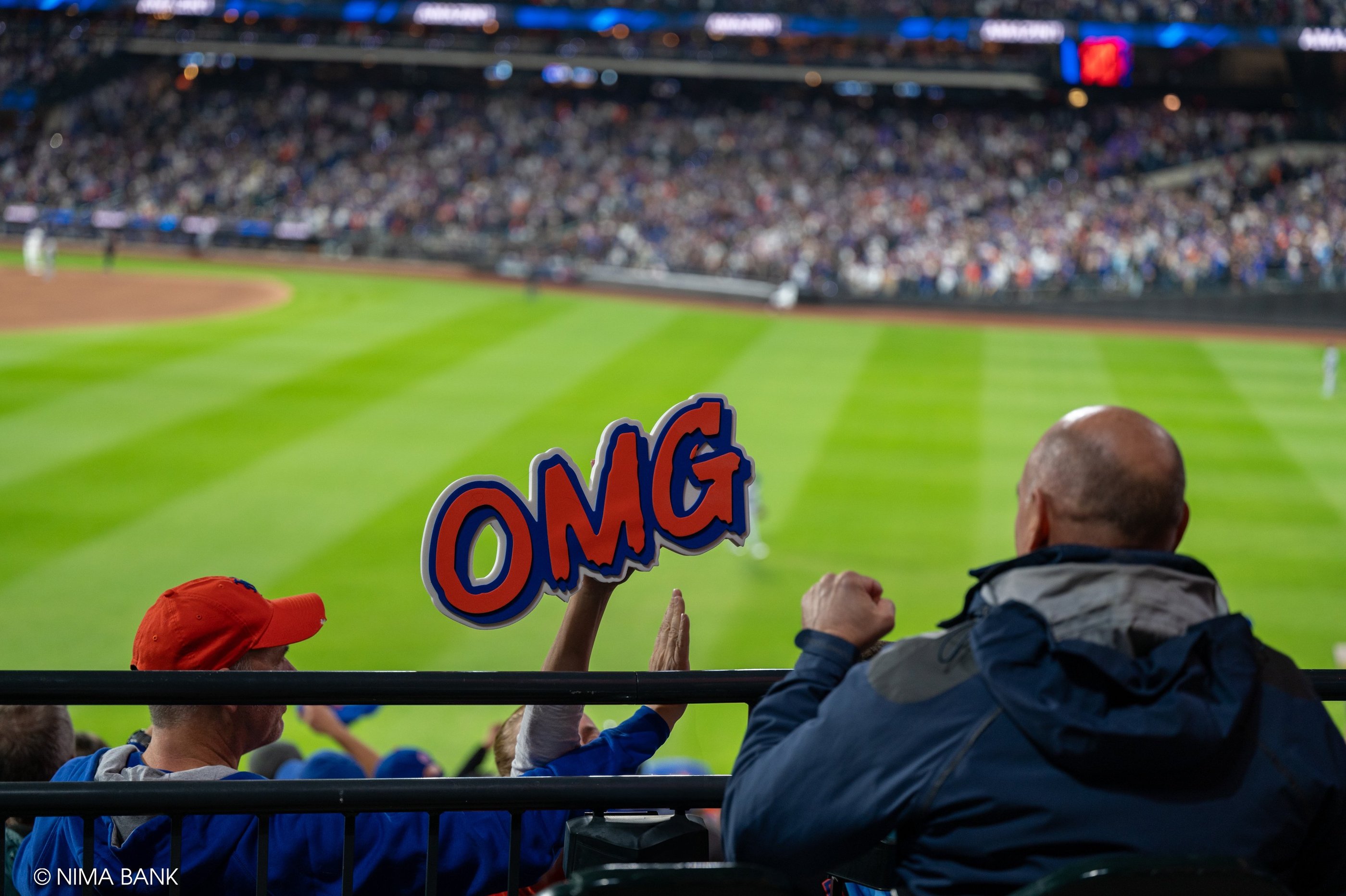 excited fans with a jose iglesias omg sign cheering the mets at citifield during nlcs game 5