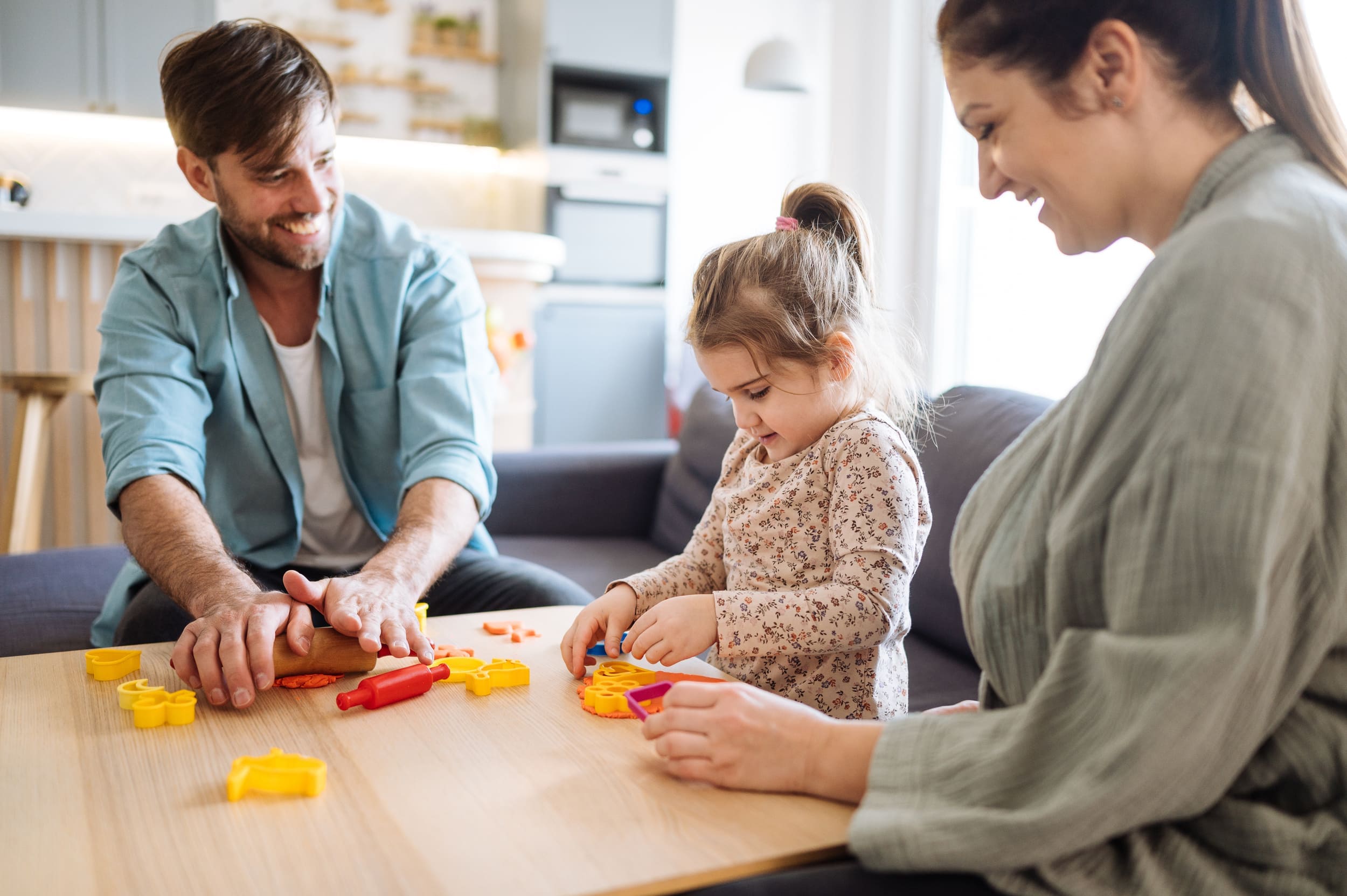 Parents participating in a child-centered speech therapy session with their school aged child.