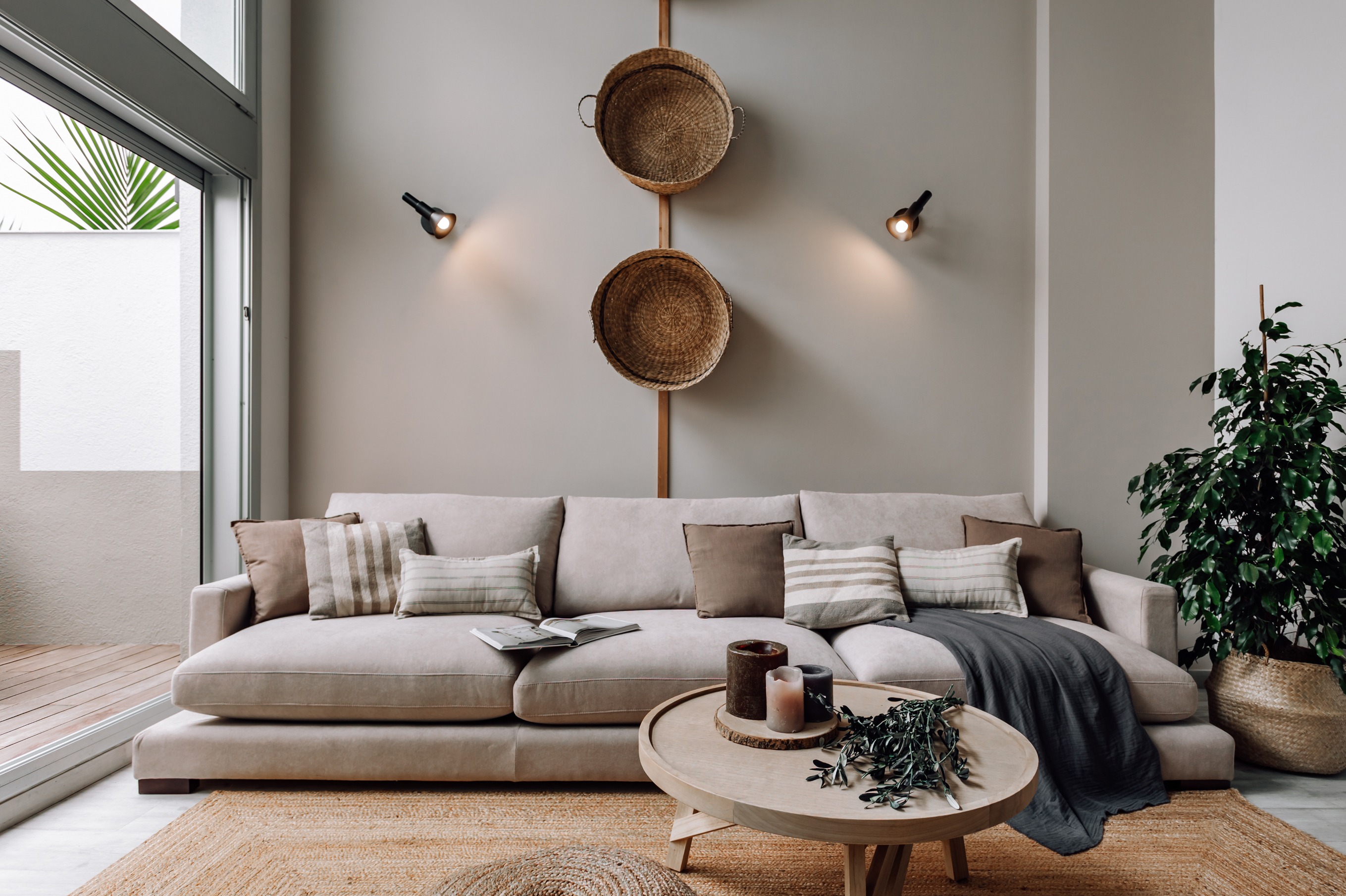 Living area with wooden elements, natural fibers and calm color palette in Barcelona interior design