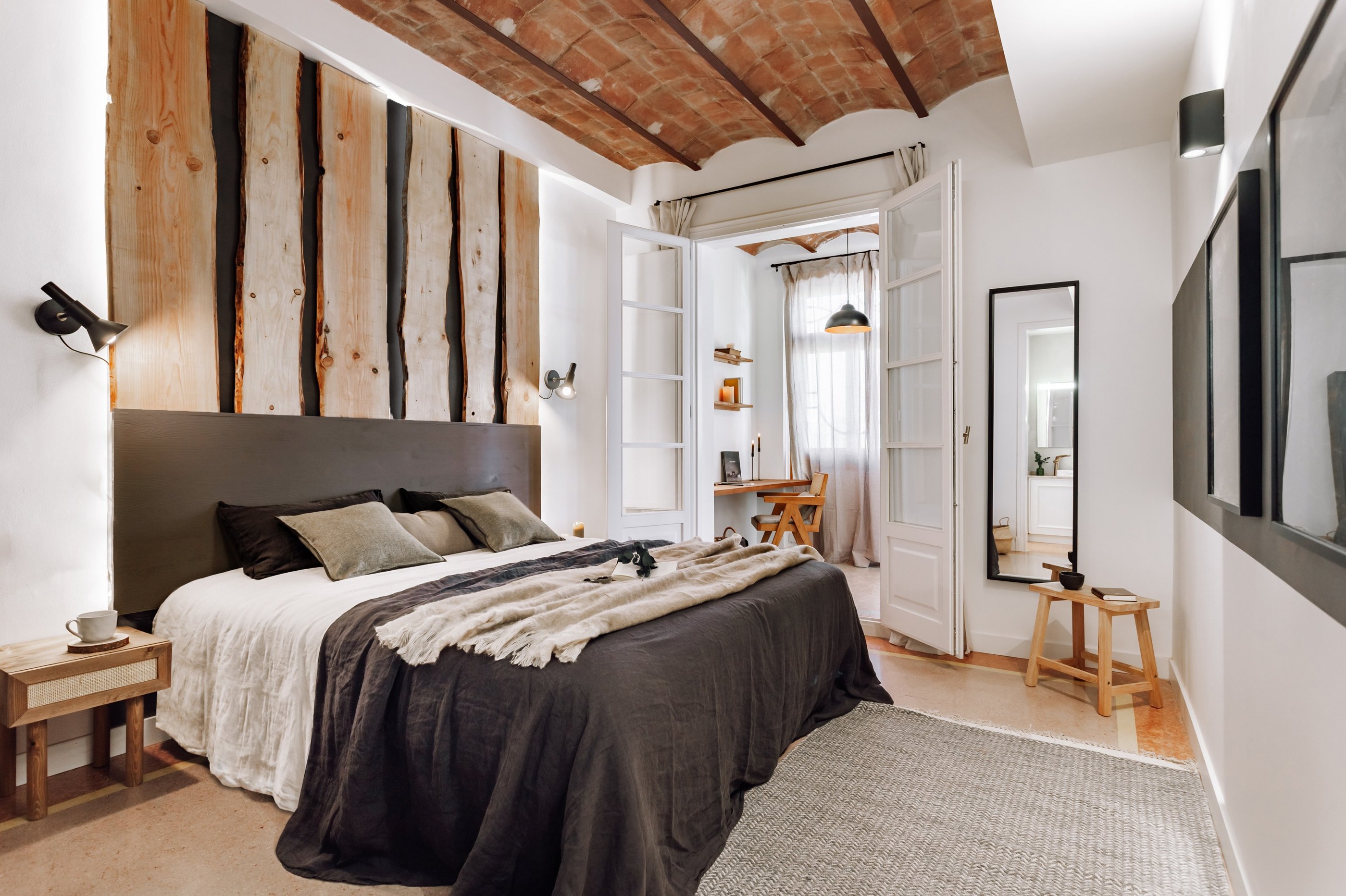 Elegant bedroom design with custom designed headboard wood panels, rustic decor and vaulted ceiling