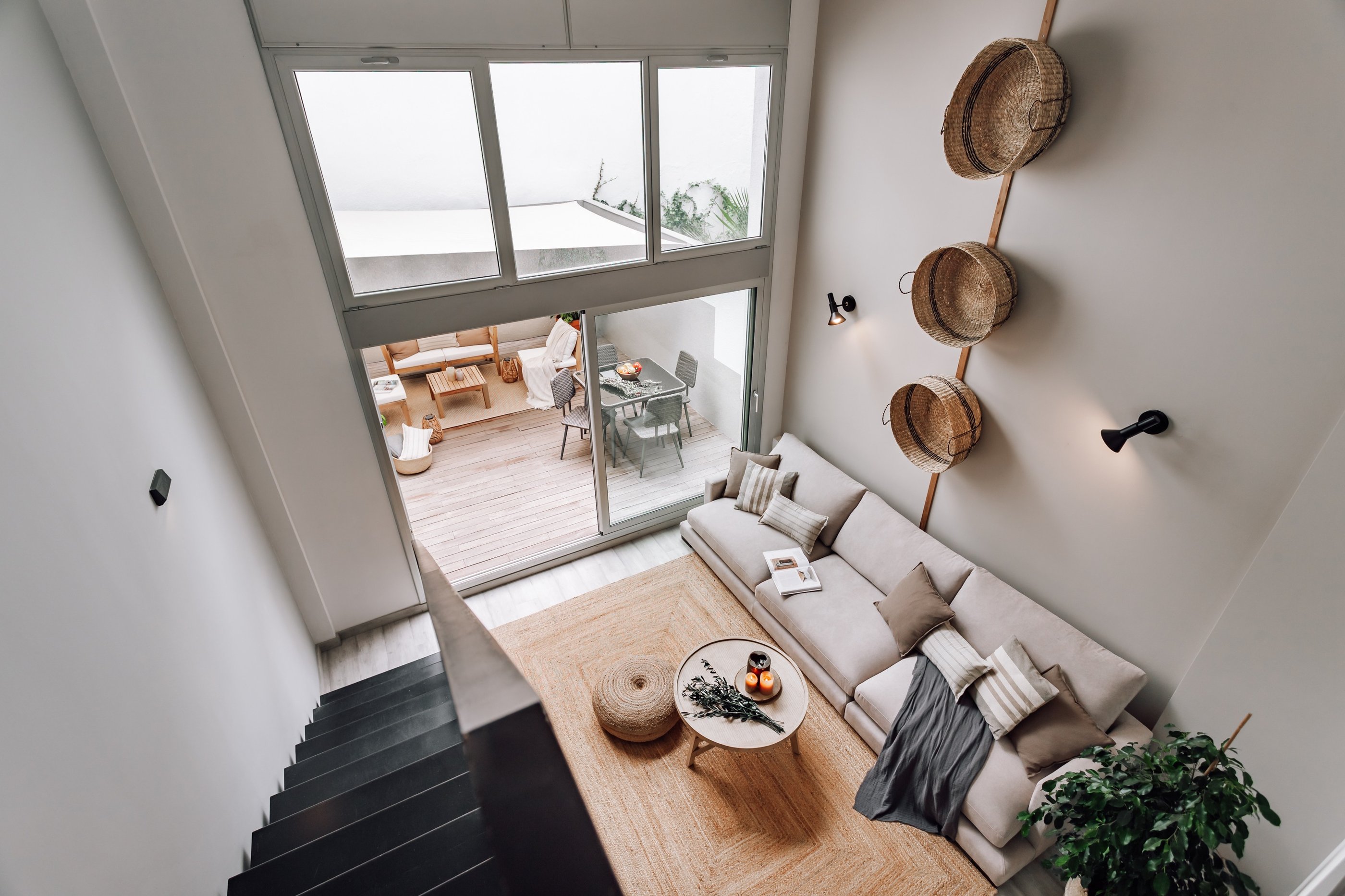 Modern living room with an iron staircase, natural wood finishes in Barcelona interior design