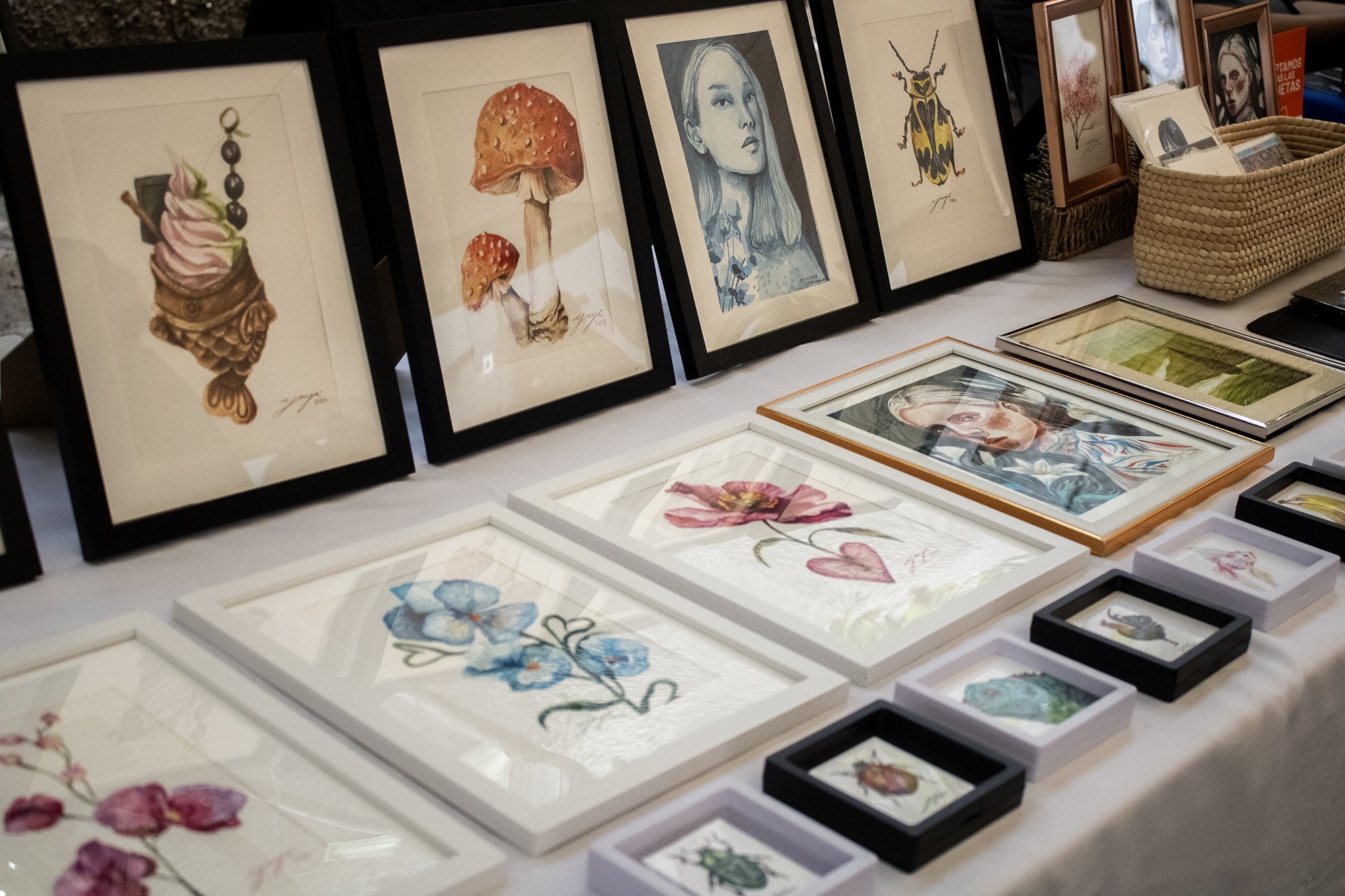 Multiple watercolor paintings displayed inside an art exhibition.