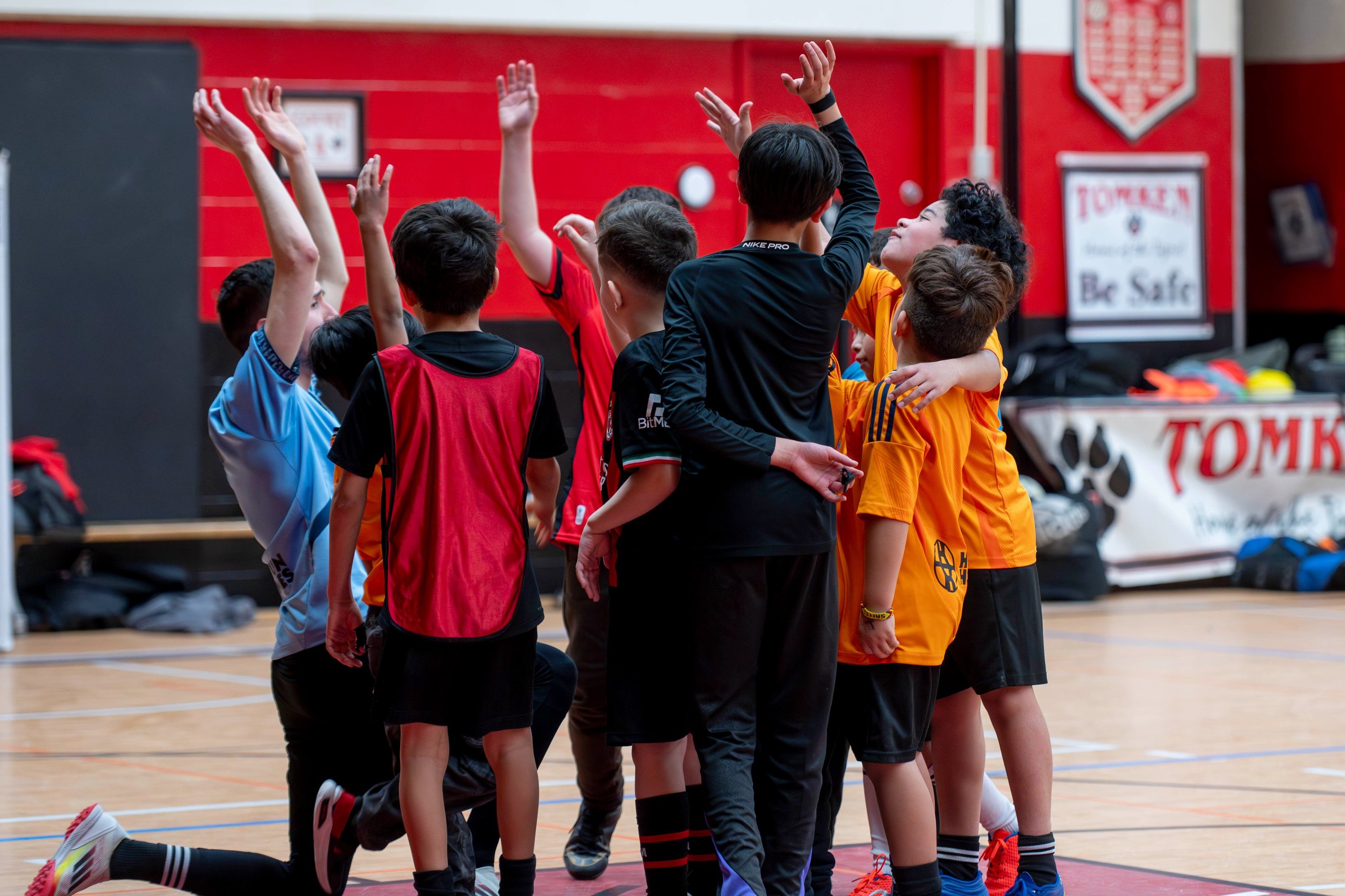 Young diverse MVB FC soccer players huddle together on an indoor soccer game in Mississauga