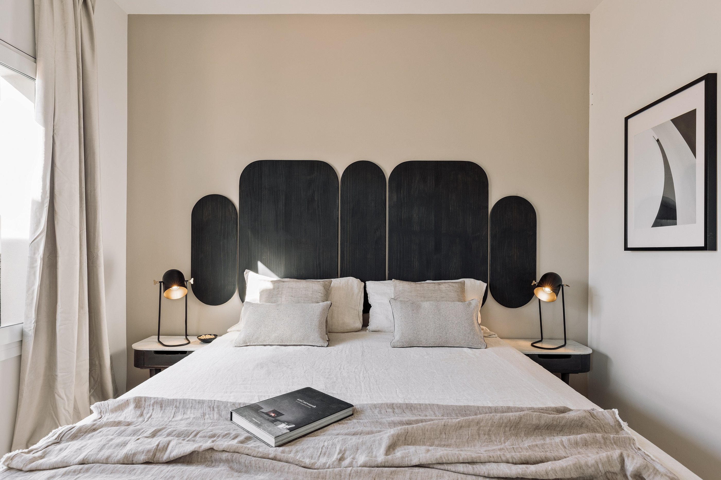Vibrant bold black wood headboard design in a bedroom with neutral colours and natural materials