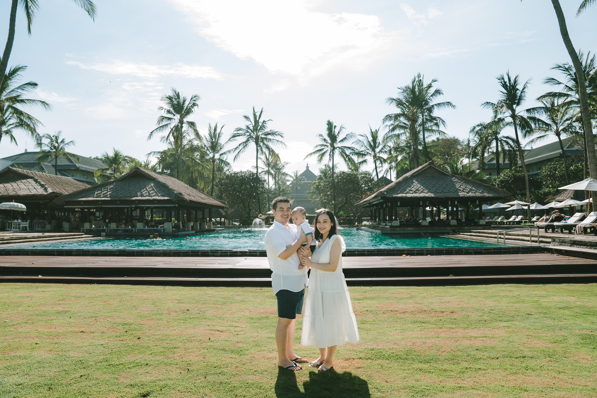Couple standing in tropical garden at Intercontinental Jimbaran during a relaxed family photography session in Bali