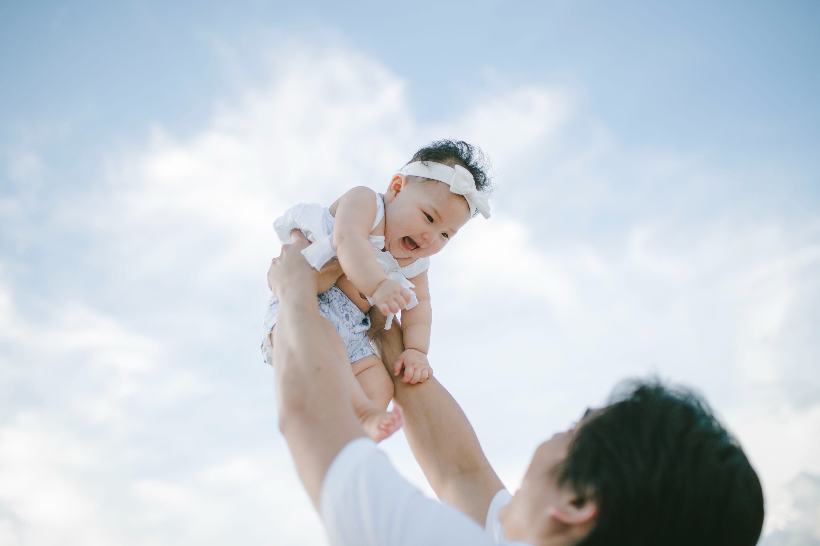 Father lifting baby into the air during family photography session at Sofitel Nusa Dua Bali