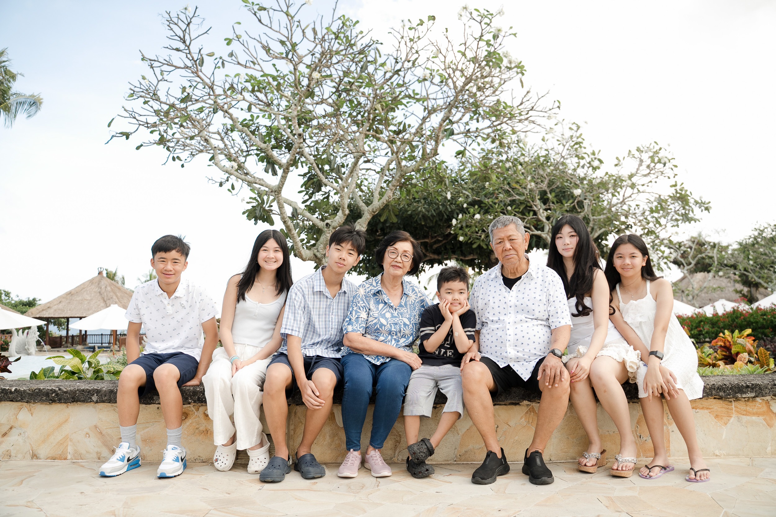 Multigenerational family sitting and sharing a relaxed moment during a lifestyle session at Ayana Resort Jimbaran Bali