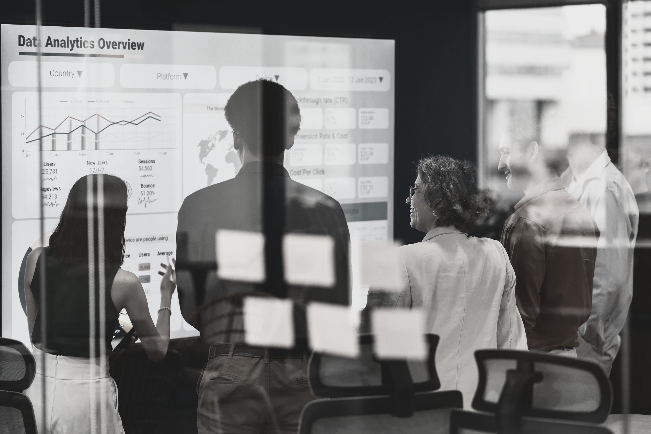 a group standing in front of a white board discussing a slide titled Data Analytics Overview