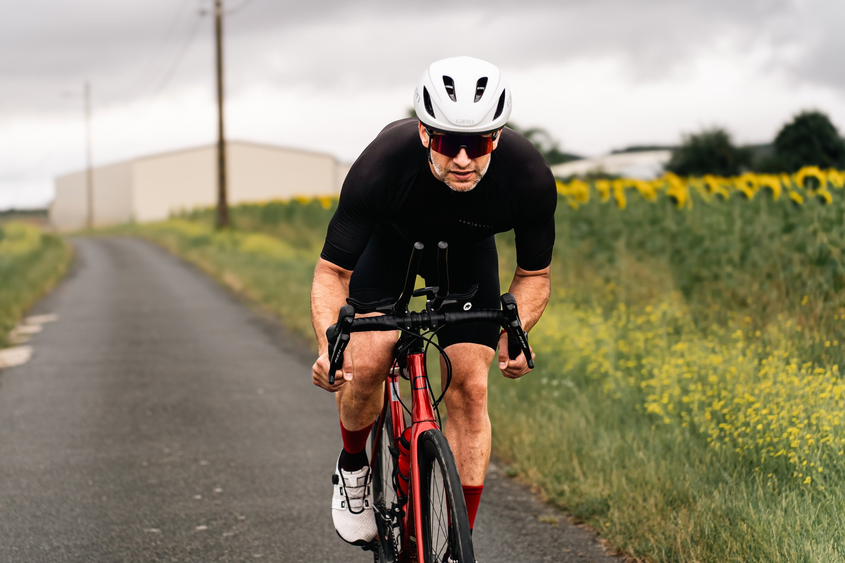 Cycliste en plein effort sur une route de campagne, photographie sportive à l’approche documentaire