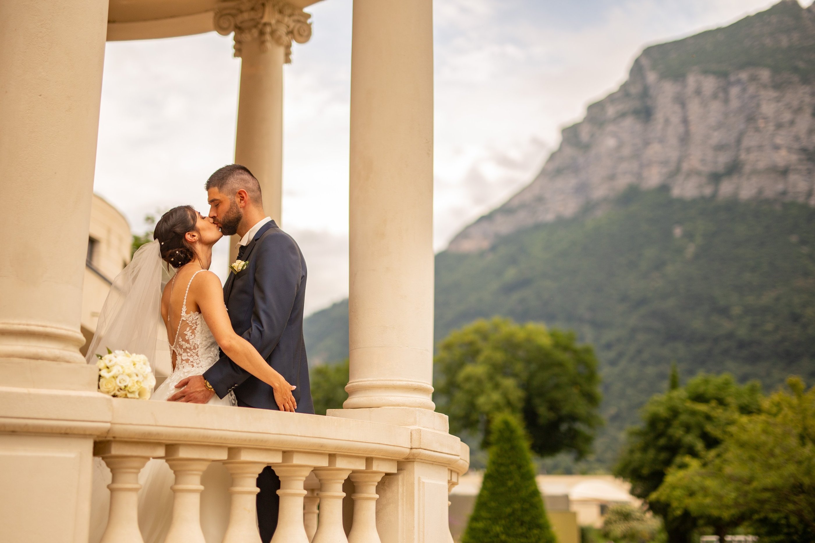 a bride and groom standing on a balcony