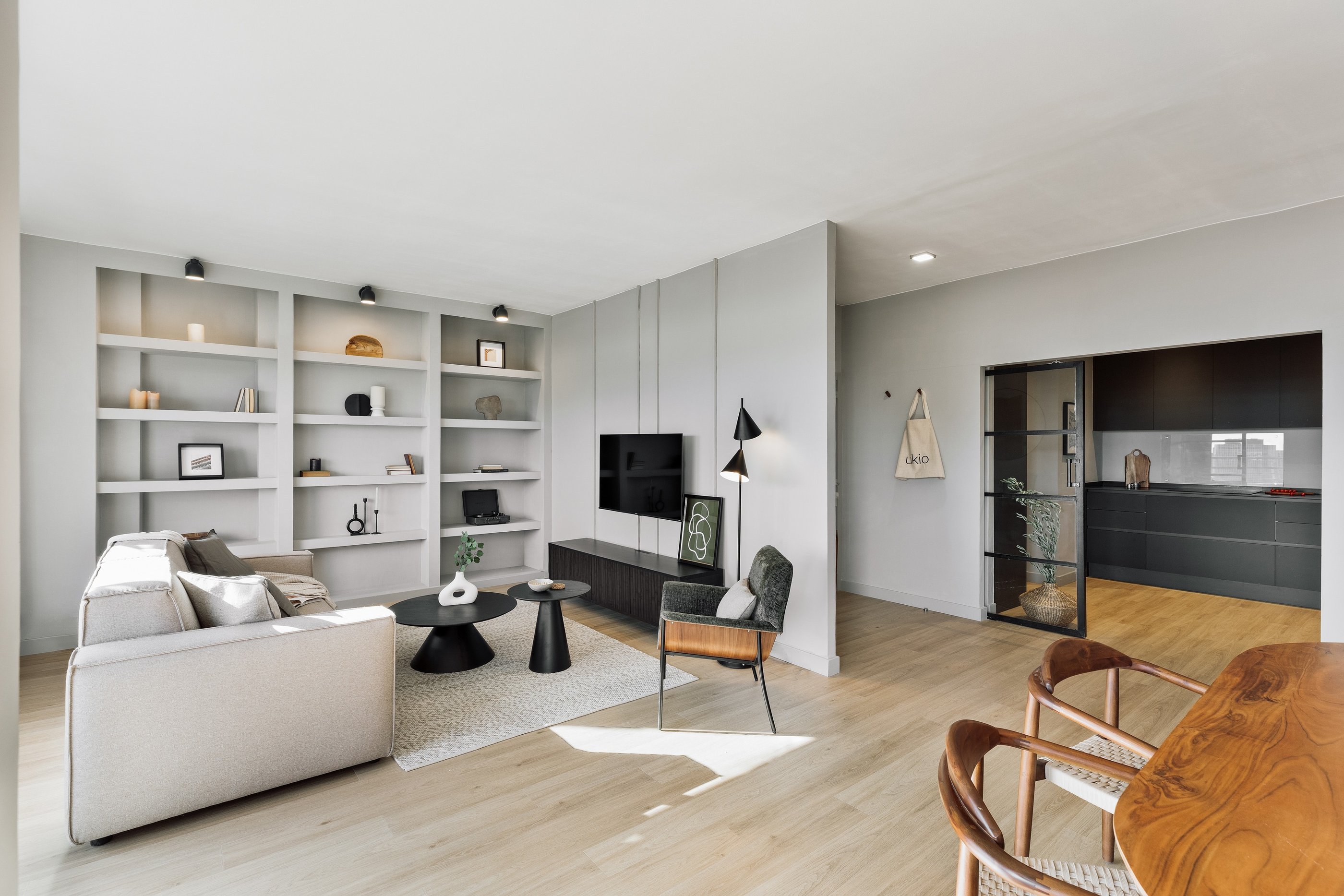 Modern living room interior design with neutral grey tones and black metal accents