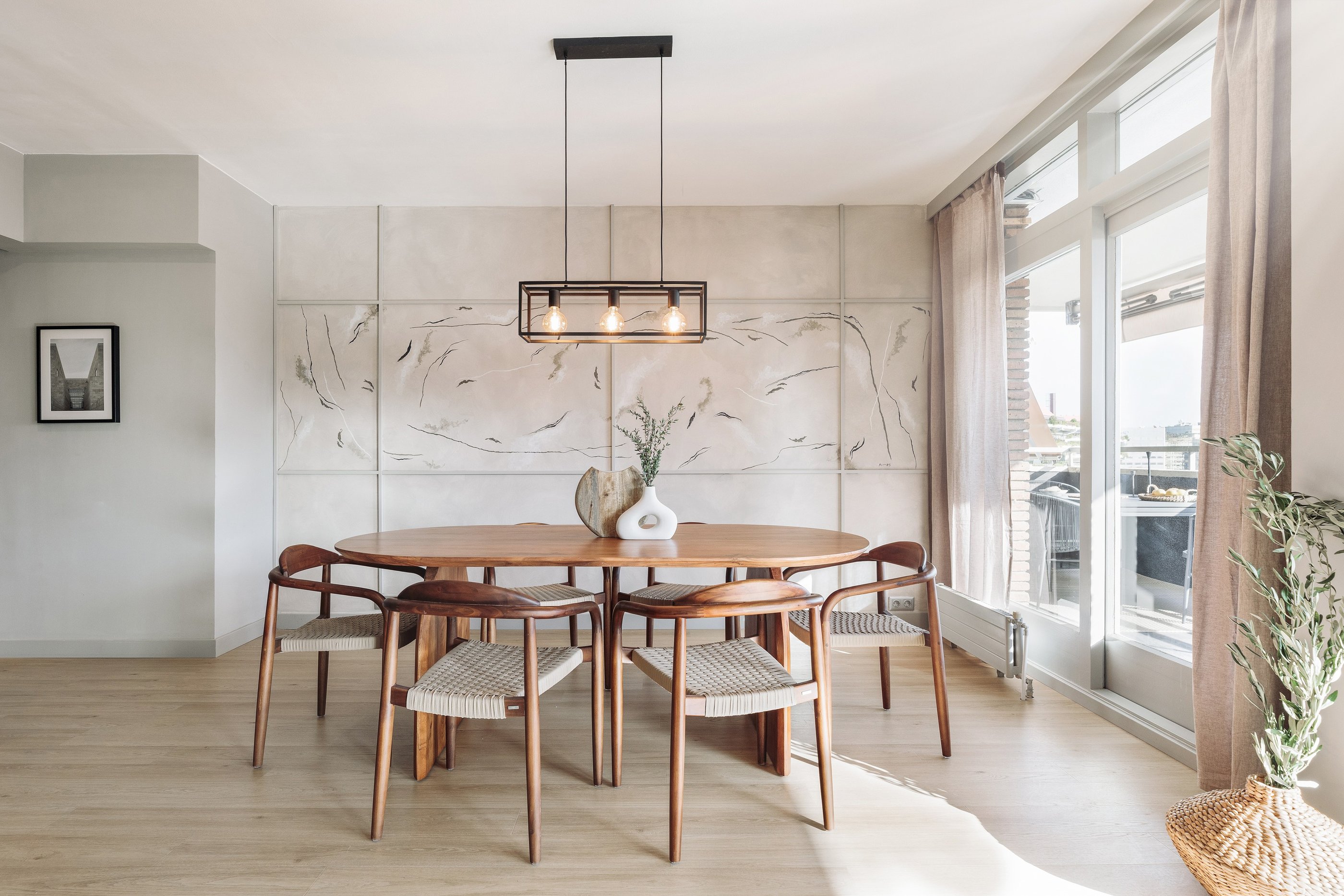 Modern dining area with metal light fixture, wooden dining table and minimalist design in Barcelona
