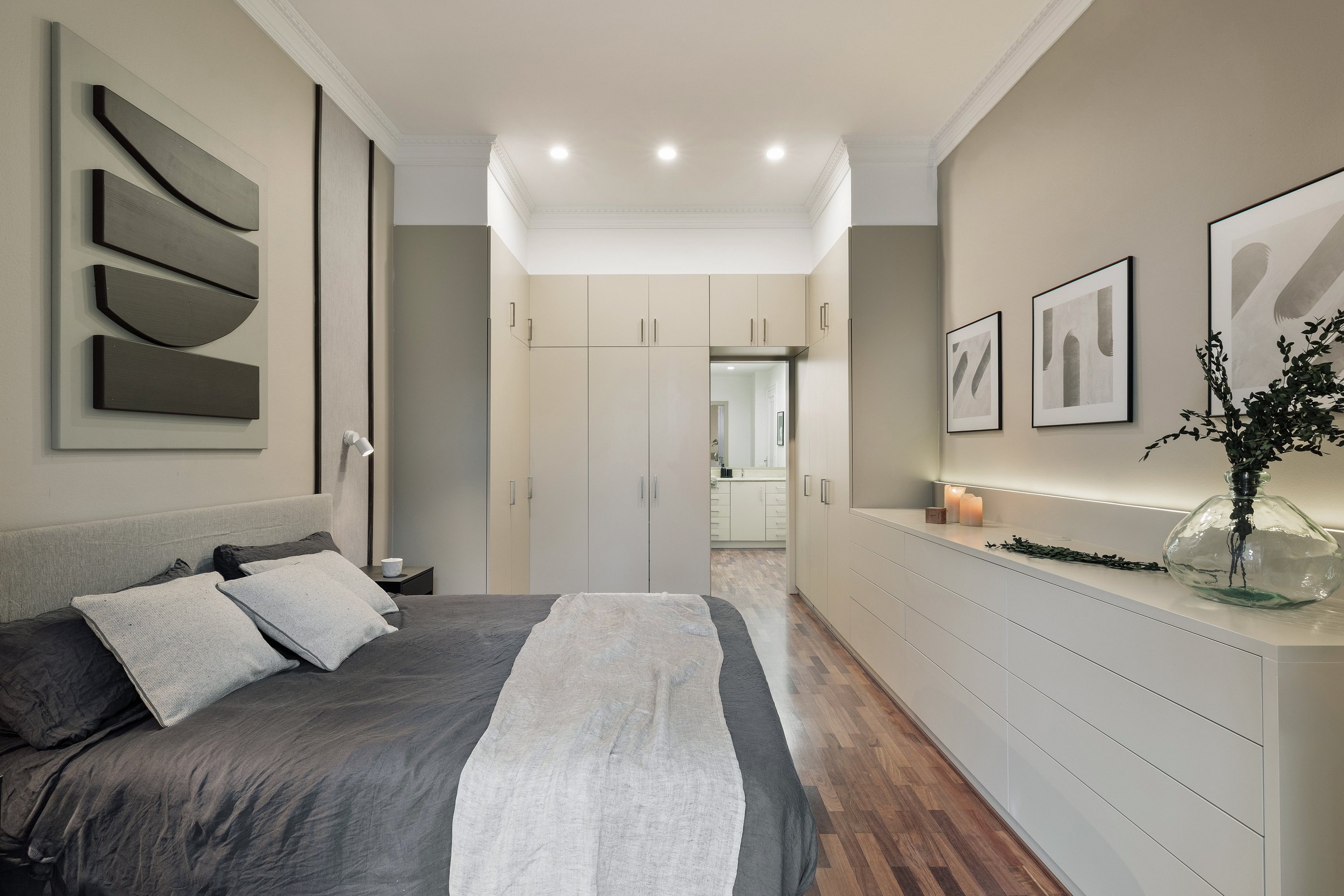 Elegant bedroom design with custom wall panels and bold decor details and integrated wardrobes