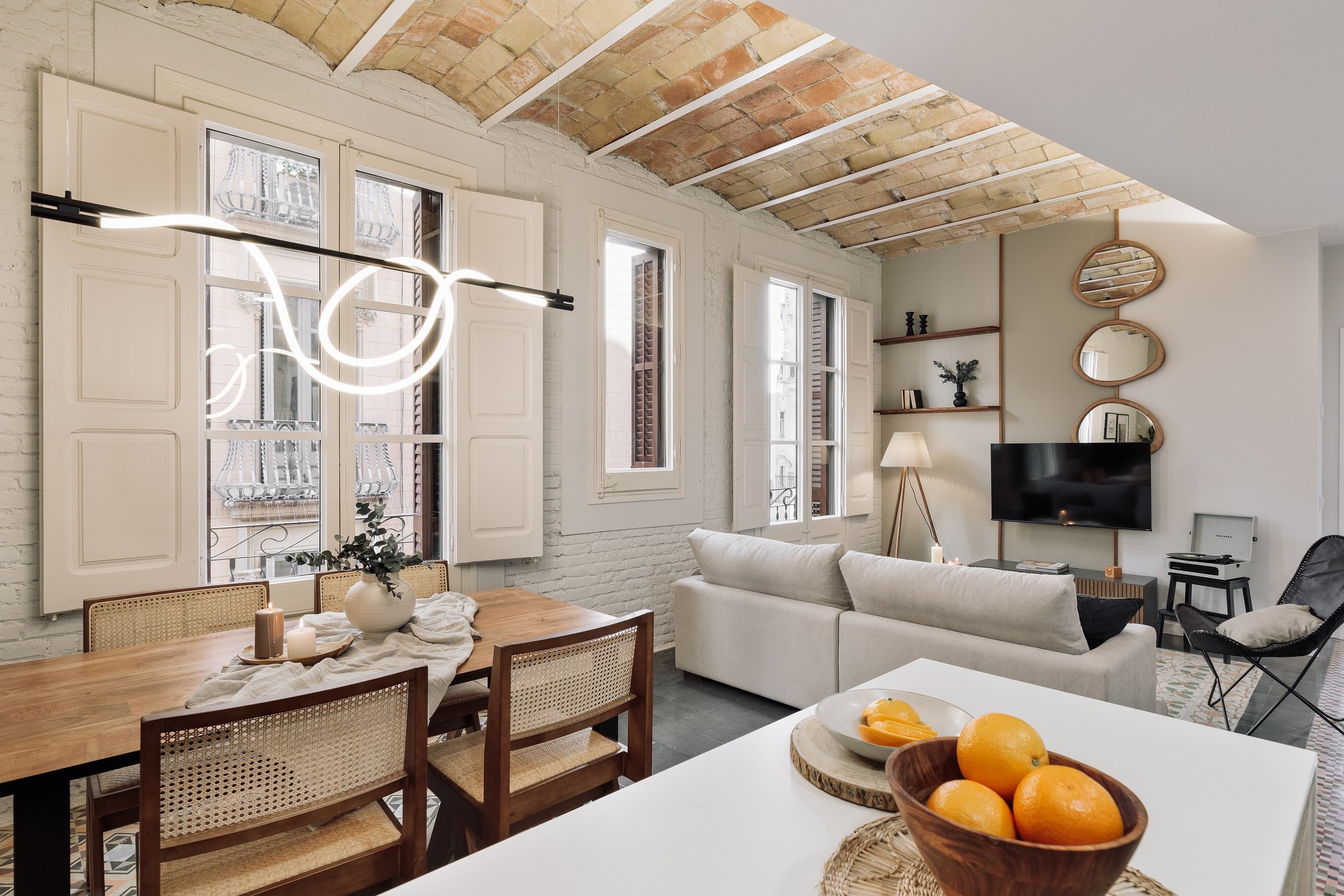 Contemporary dining with rattan furniture, custom lighting, colorful floor tiles, designed by SAVIA 