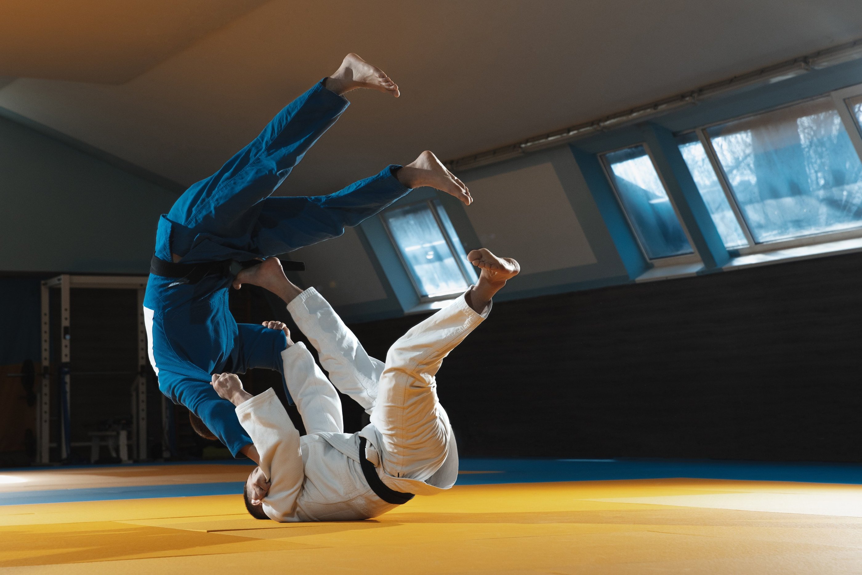 Judokas ceinture noir, réalisant une projection de judo sur un tatami