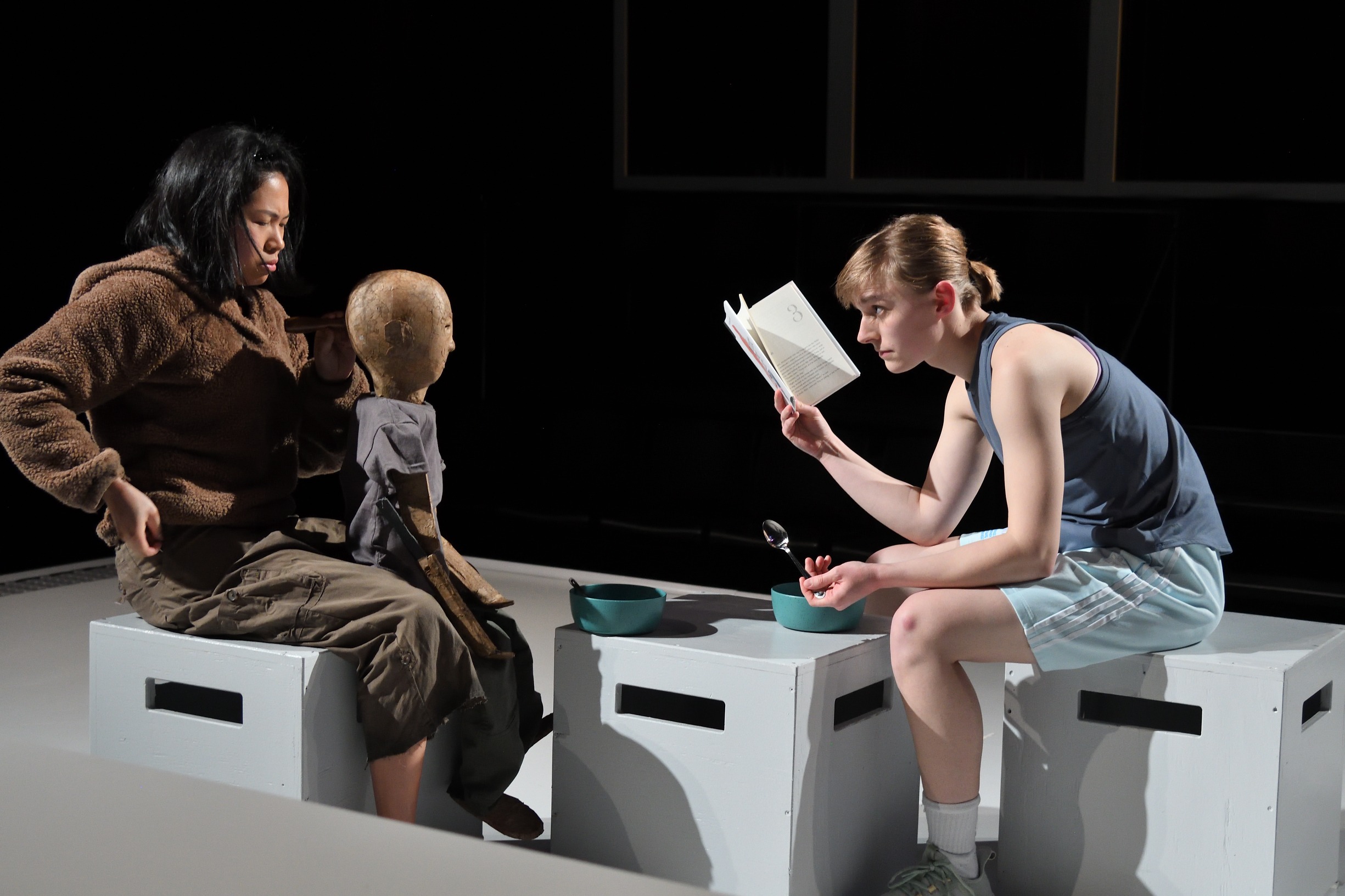 Jordan Palmer, actor and physical comedian, reads a book to a weathered puppet during performance