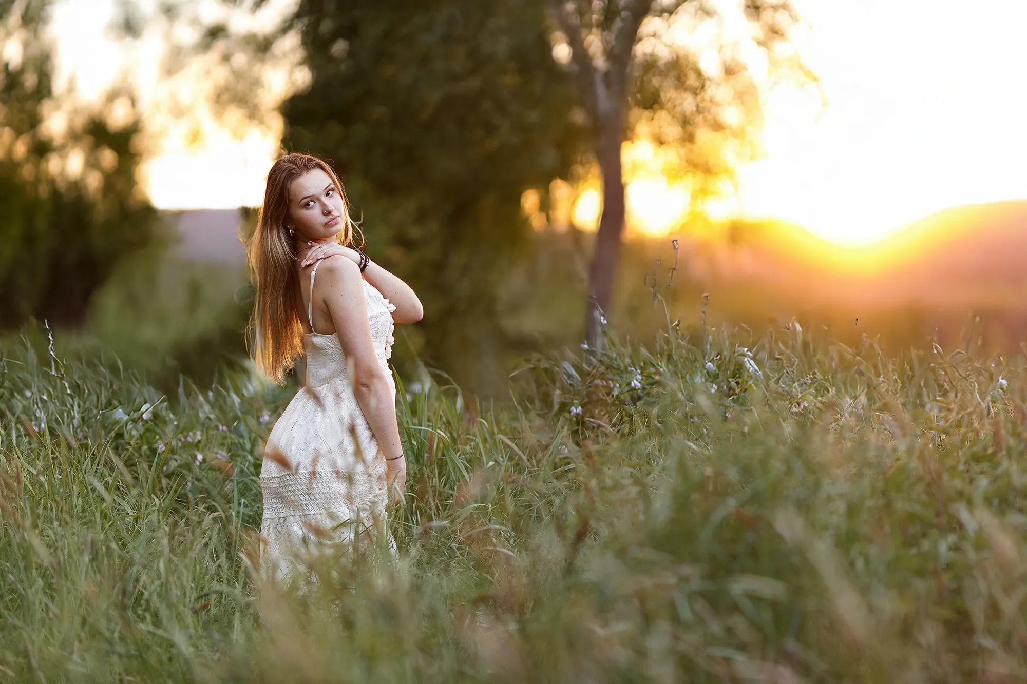 une jeune femme pose pour une séance photo au soleil couchant