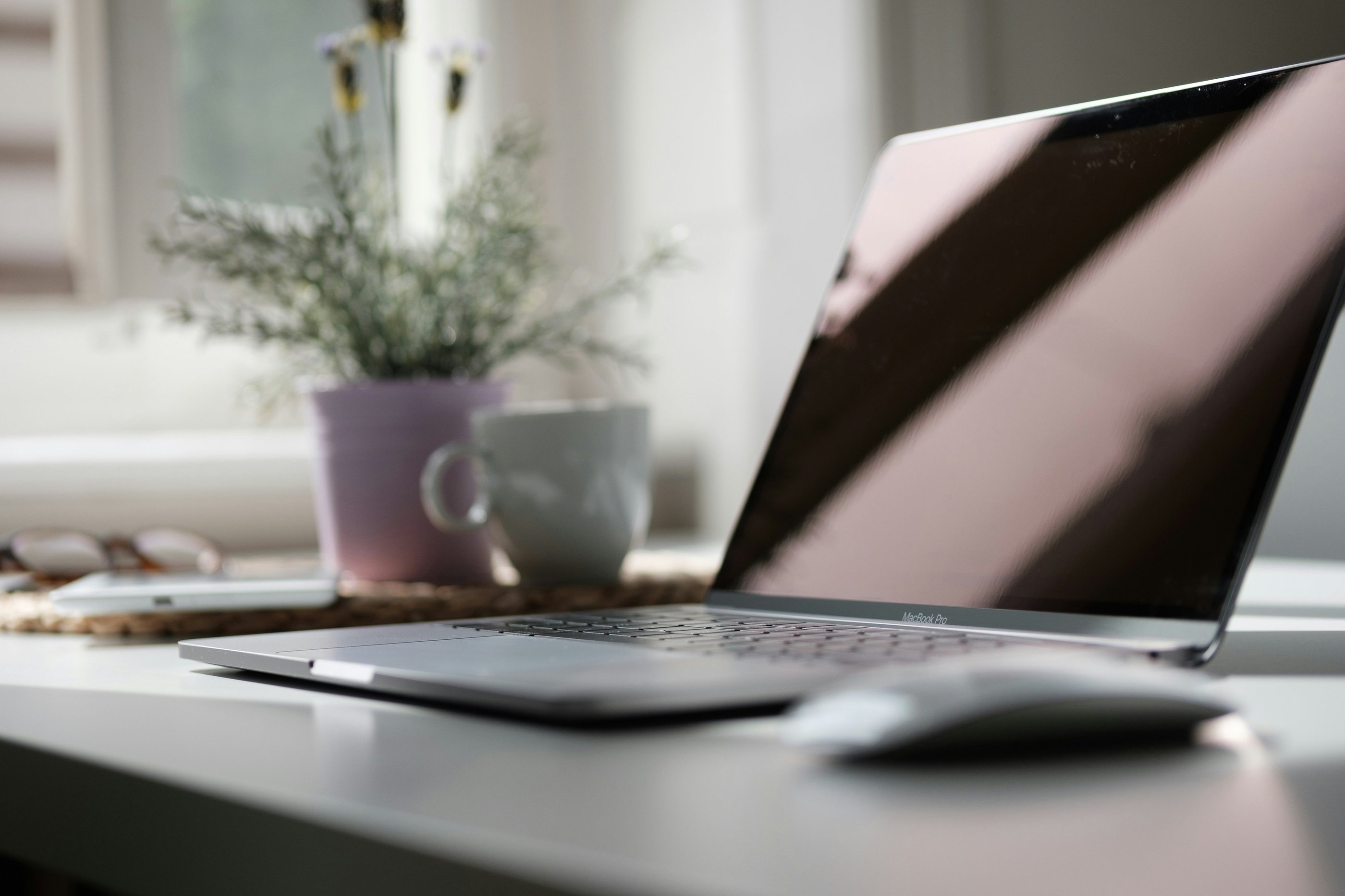 A designer's desk with a MacBook and a cup of coffee.