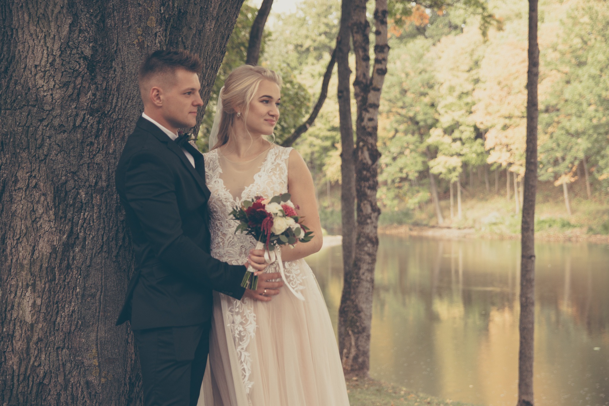 Romantiška nuotrauka, kurioje jaunavedžiai žvelgiantys kryptingai į vieną pusę