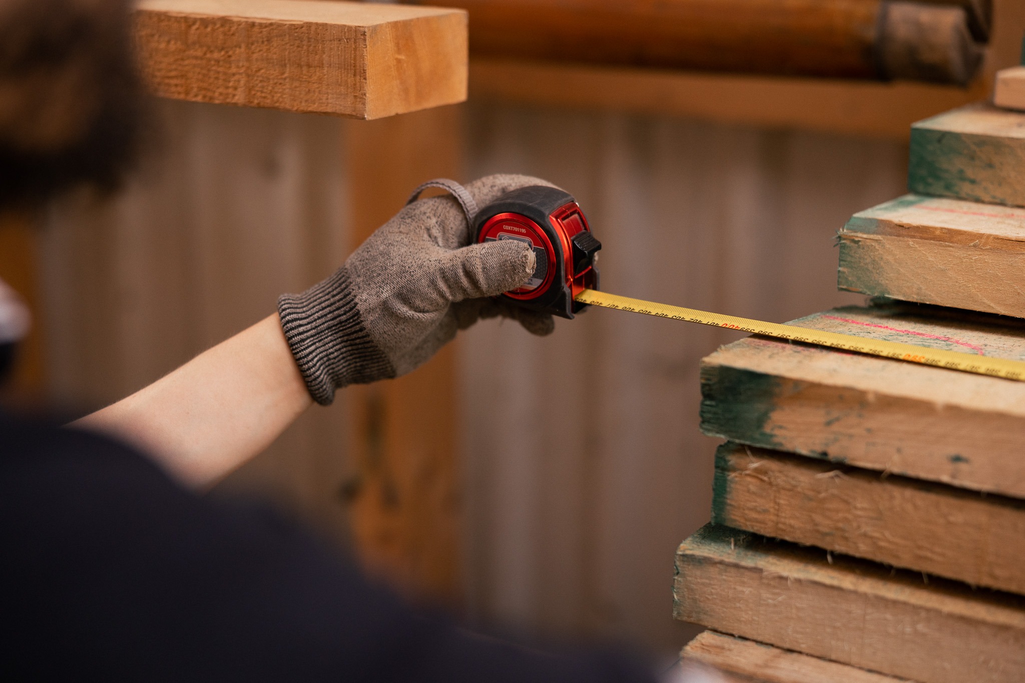 a person holding a tape measure ruler and measuring tape measure tape on wood wood plank