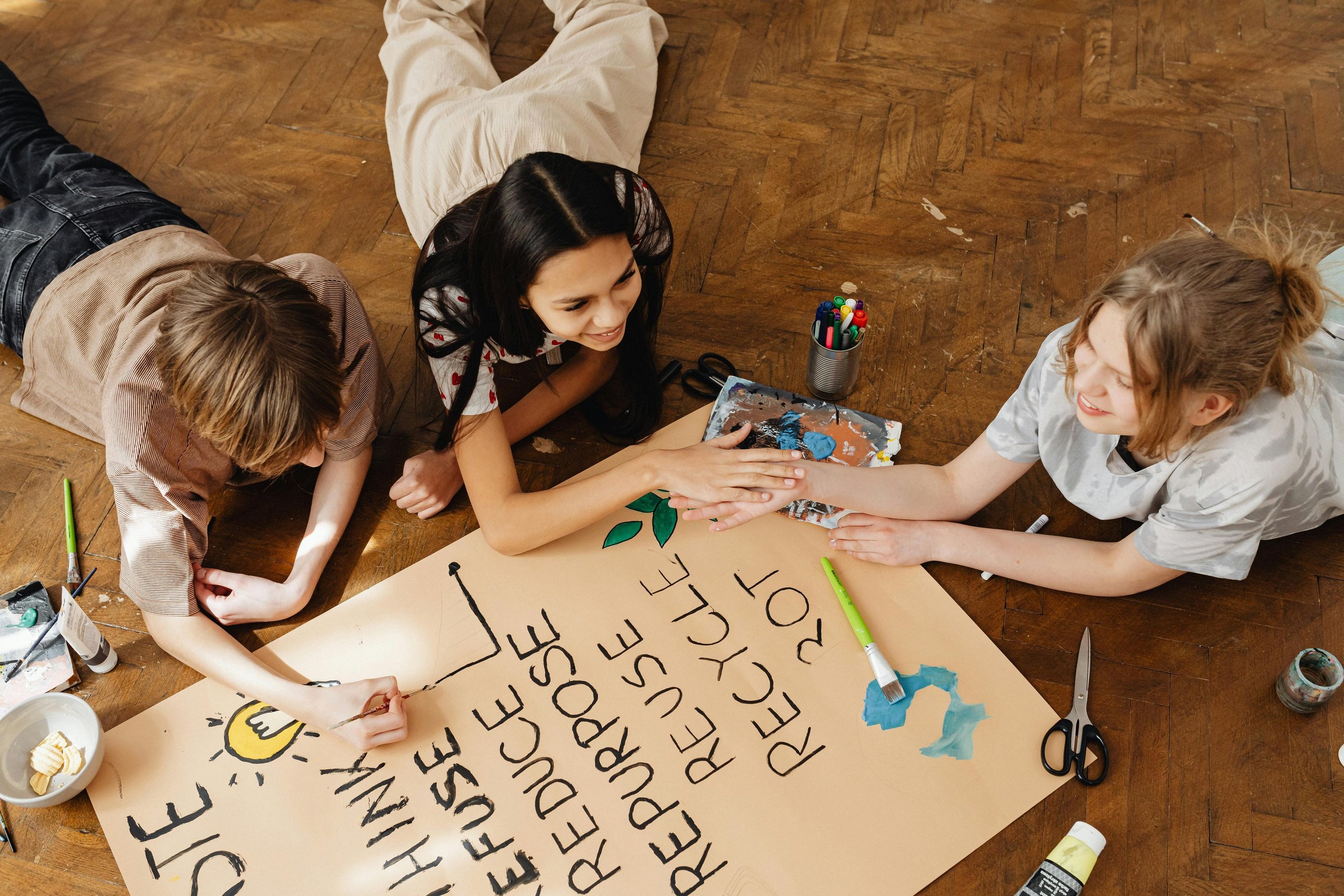 Photo by Photo By: Kaboompics.com: https://www.pexels.com/photo/friends-painting-on-brown-paper-7692