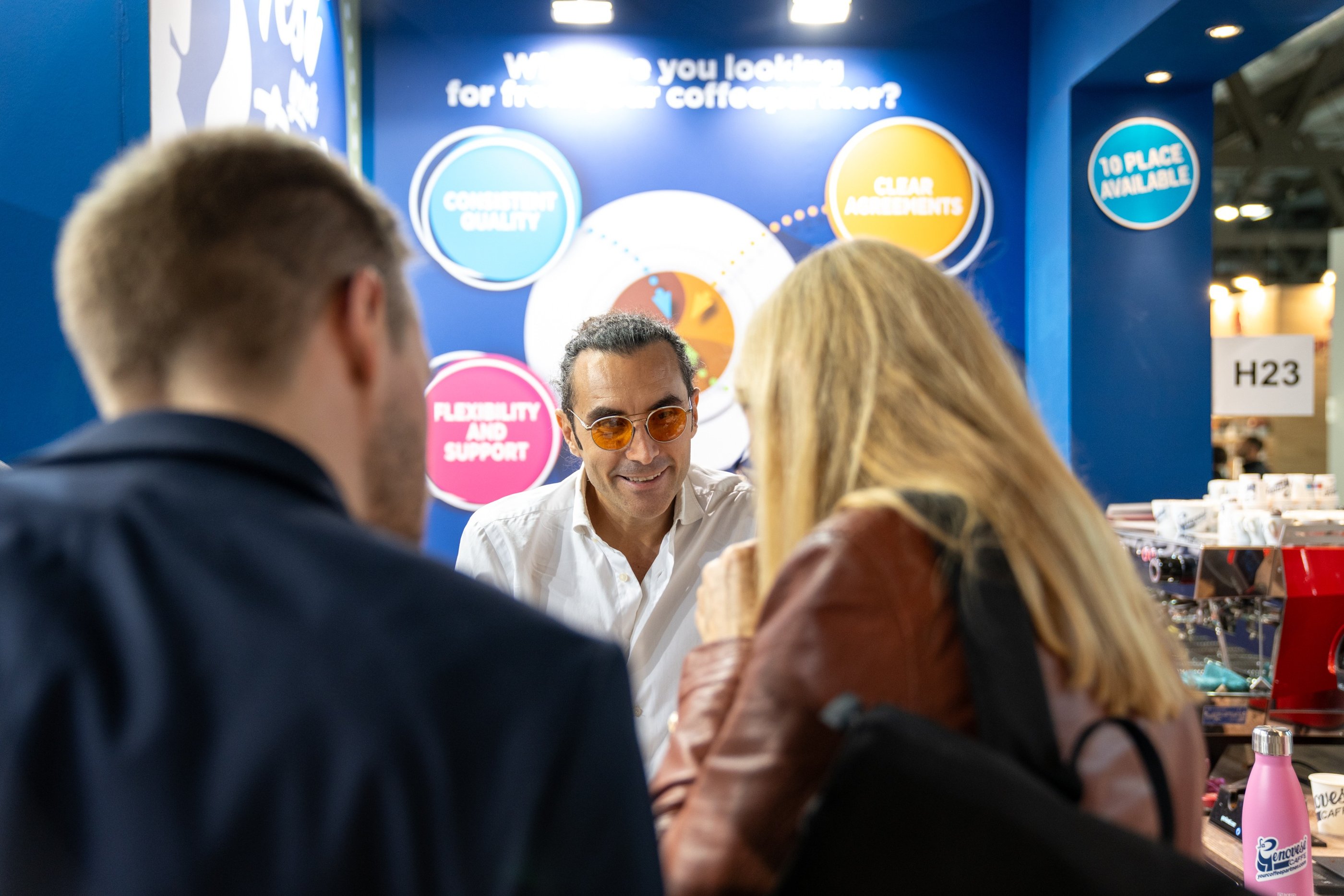 Matteo Borea smiling with customers during a coffee exhibition