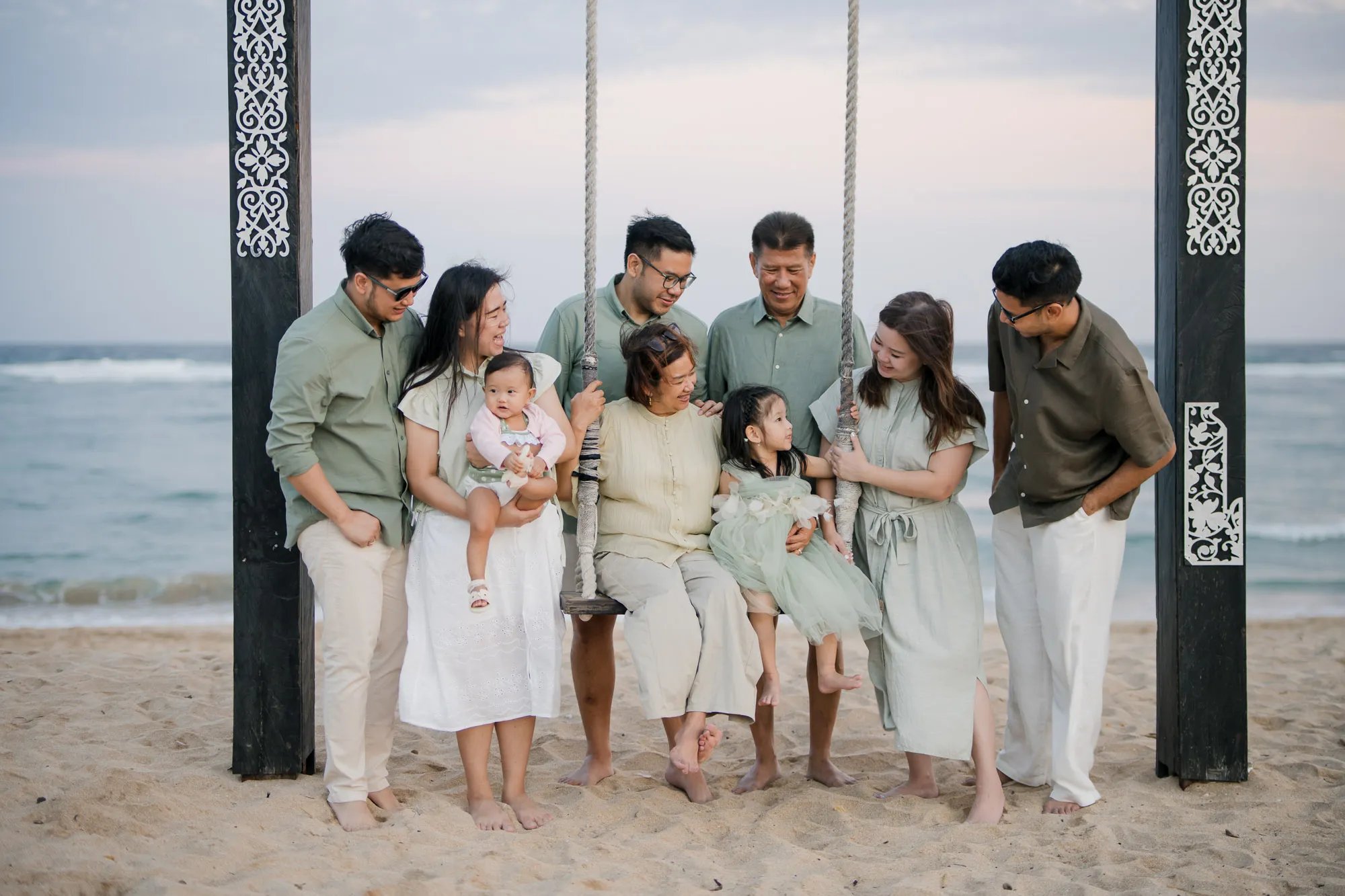 Multigenerational family gathered beneath a beach pavilion during a family photography session in Nusa Dua Bali.