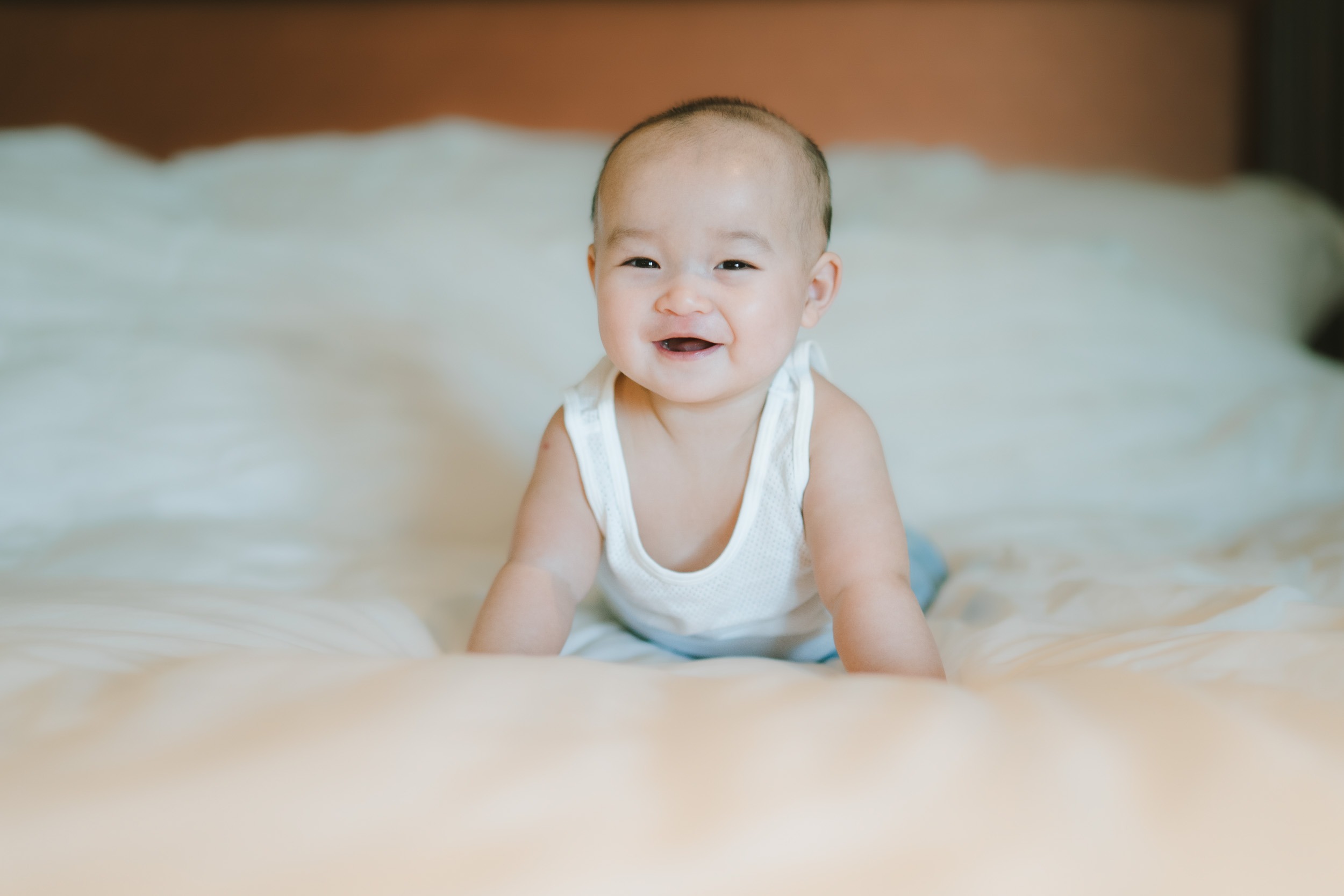 Baby portrait on bed at Intercontinental Jimbaran captured in soft natural light during a family photography session