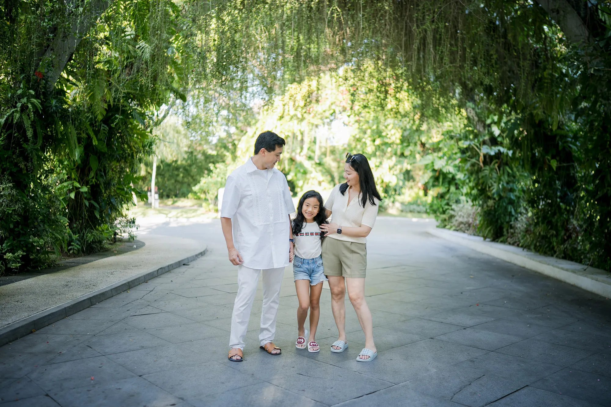 Family strolling through a tropical garden pathway during a family photography session at InterContinental Bali Resort