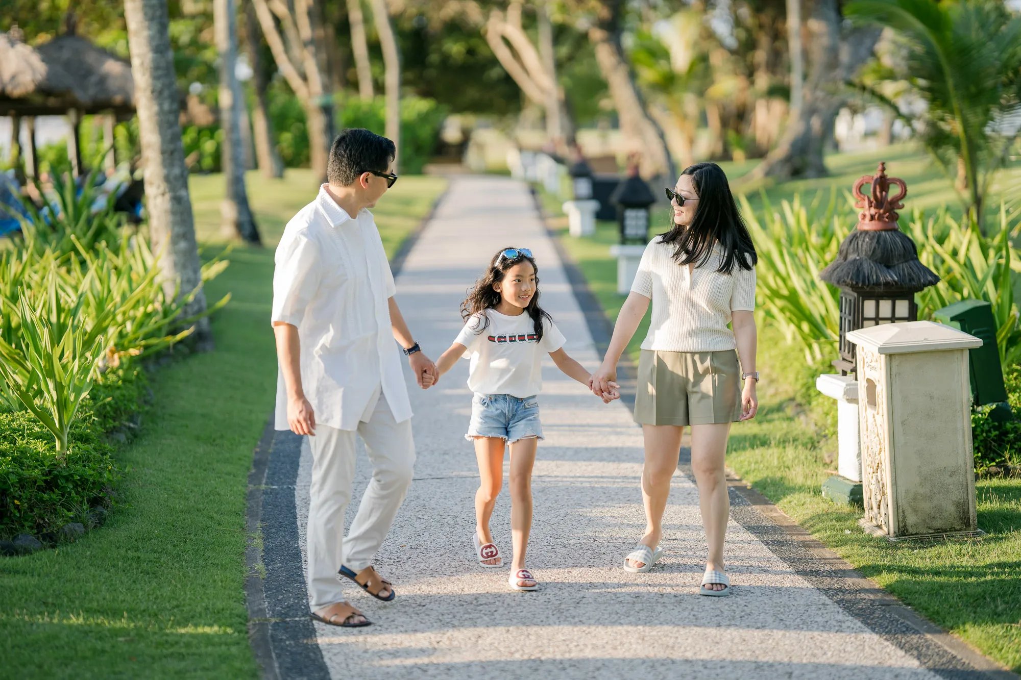 Family walking along a garden pathway during a family photography session at InterContinental Bali Resort