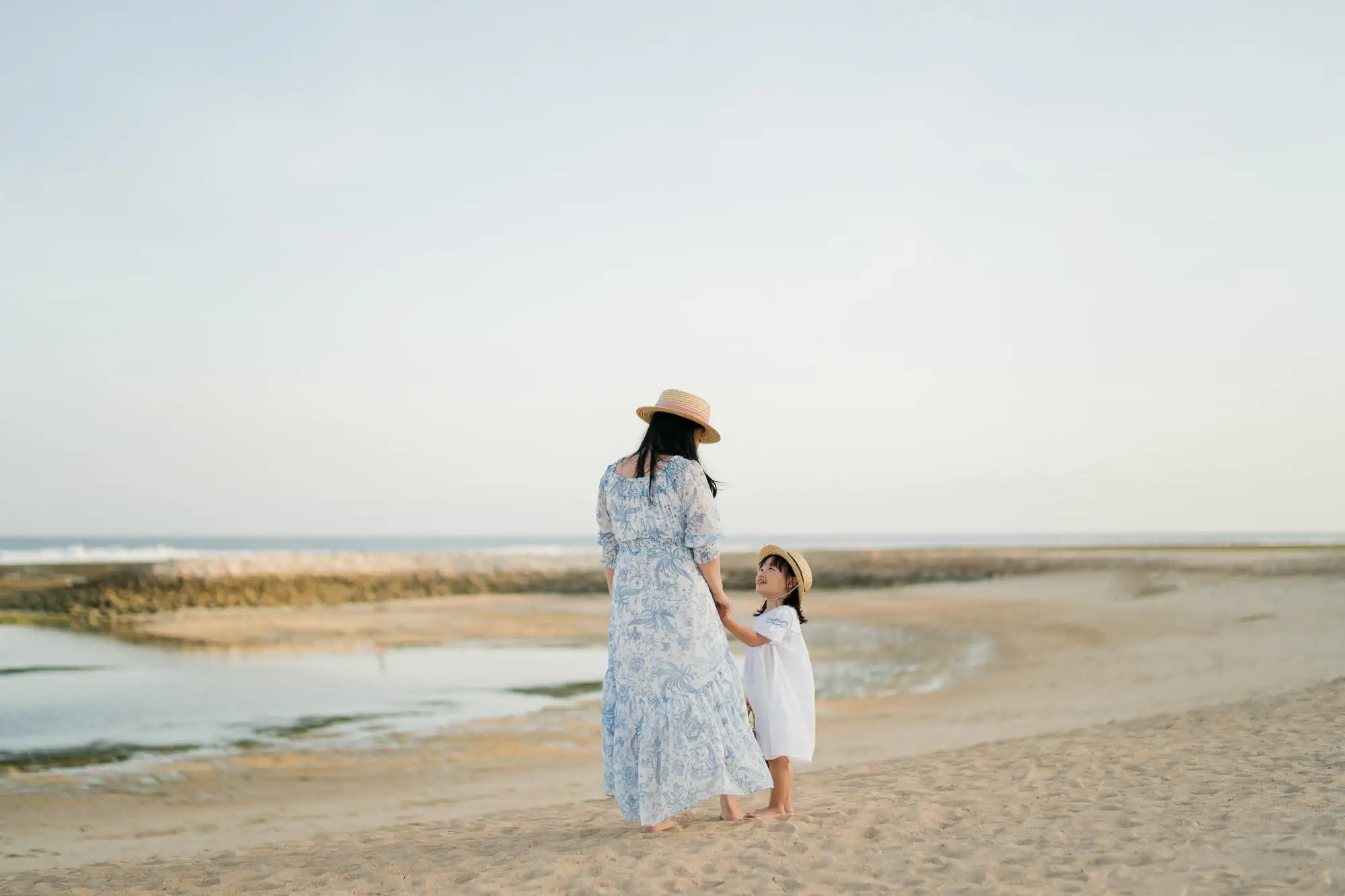 Family portrait overlooking the shoreline at The Apurva Kempinski Bali.