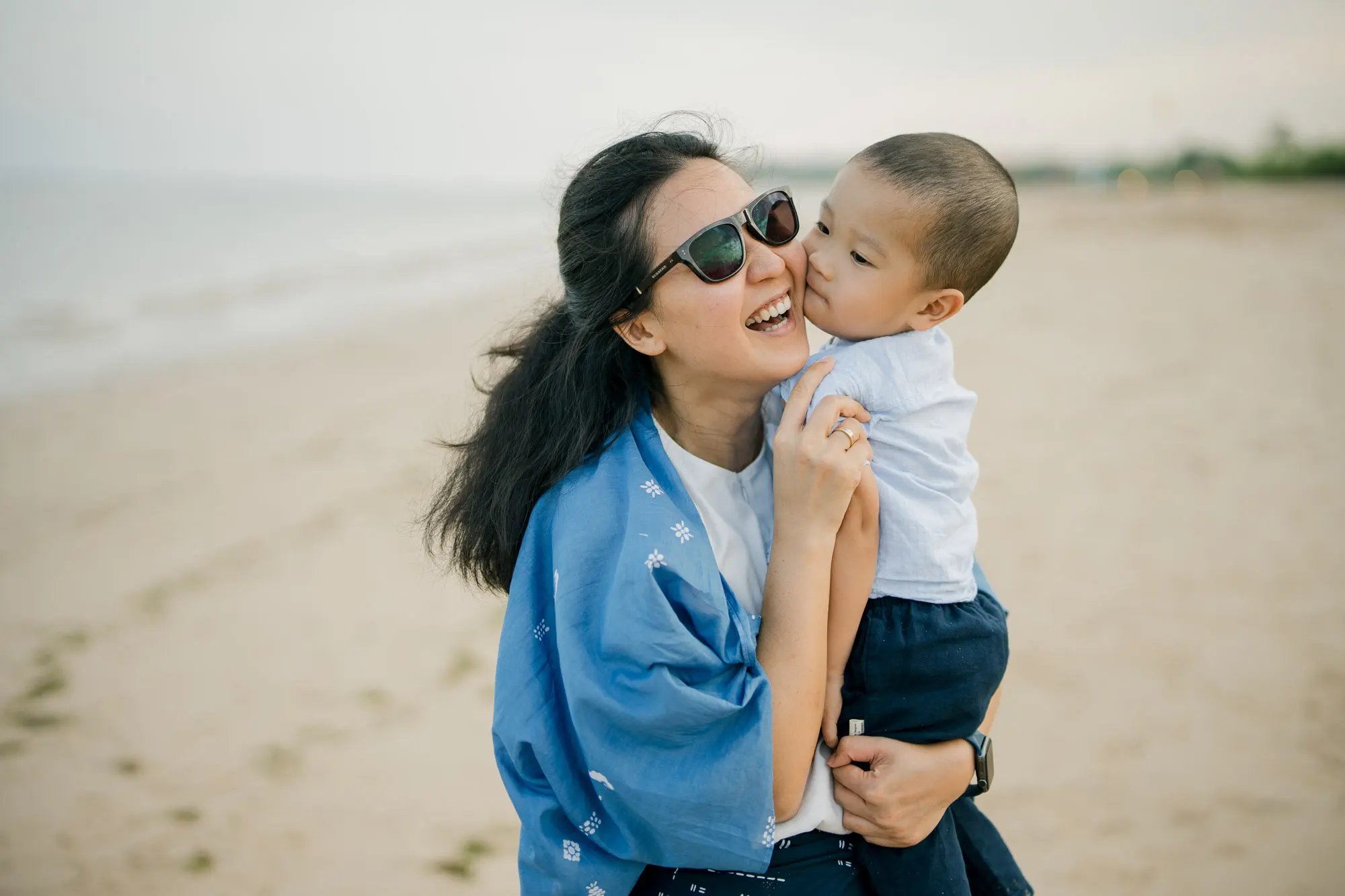 Mother holding her son during a relaxed family photography session at Nusa Dua Beach Bali