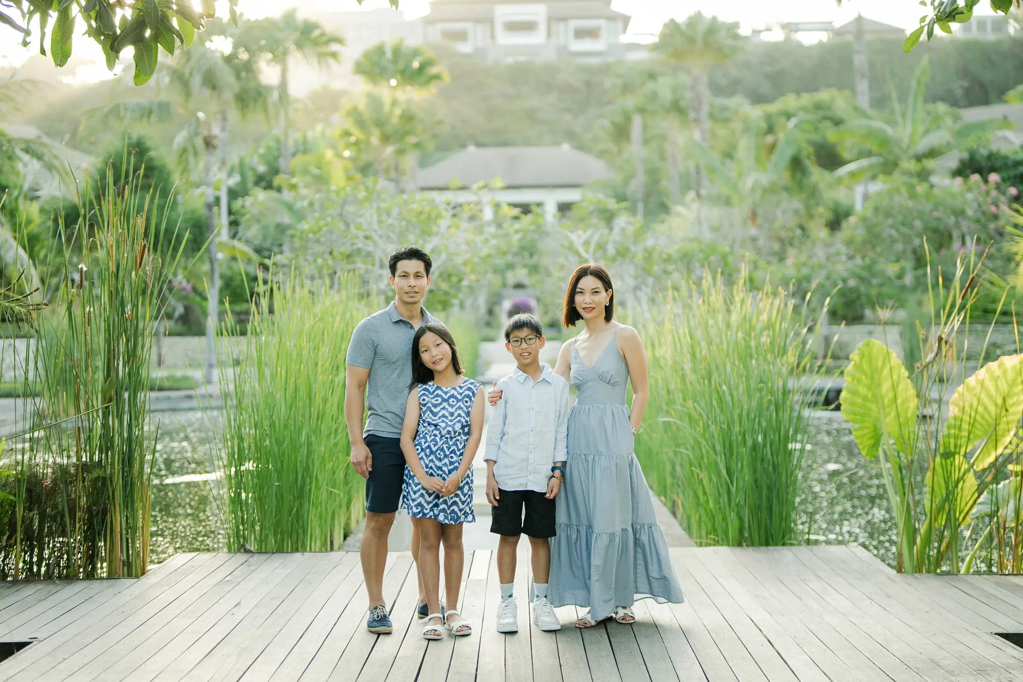Family portrait at The Ritz-Carlton Bali surrounded by tropical gardens during a luxury family photography session.