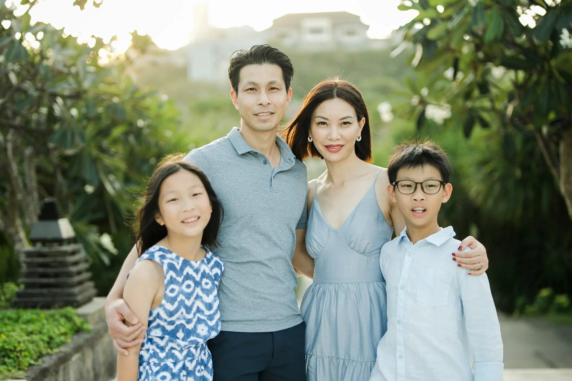 Family portrait surrounded by lush tropical gardens during a luxury family photography session at The Ritz-Carlton Bali.