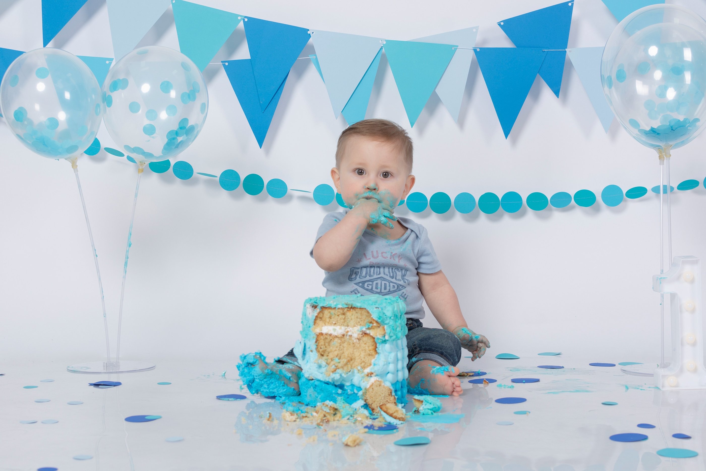 a baby boy in a blue birthday cake