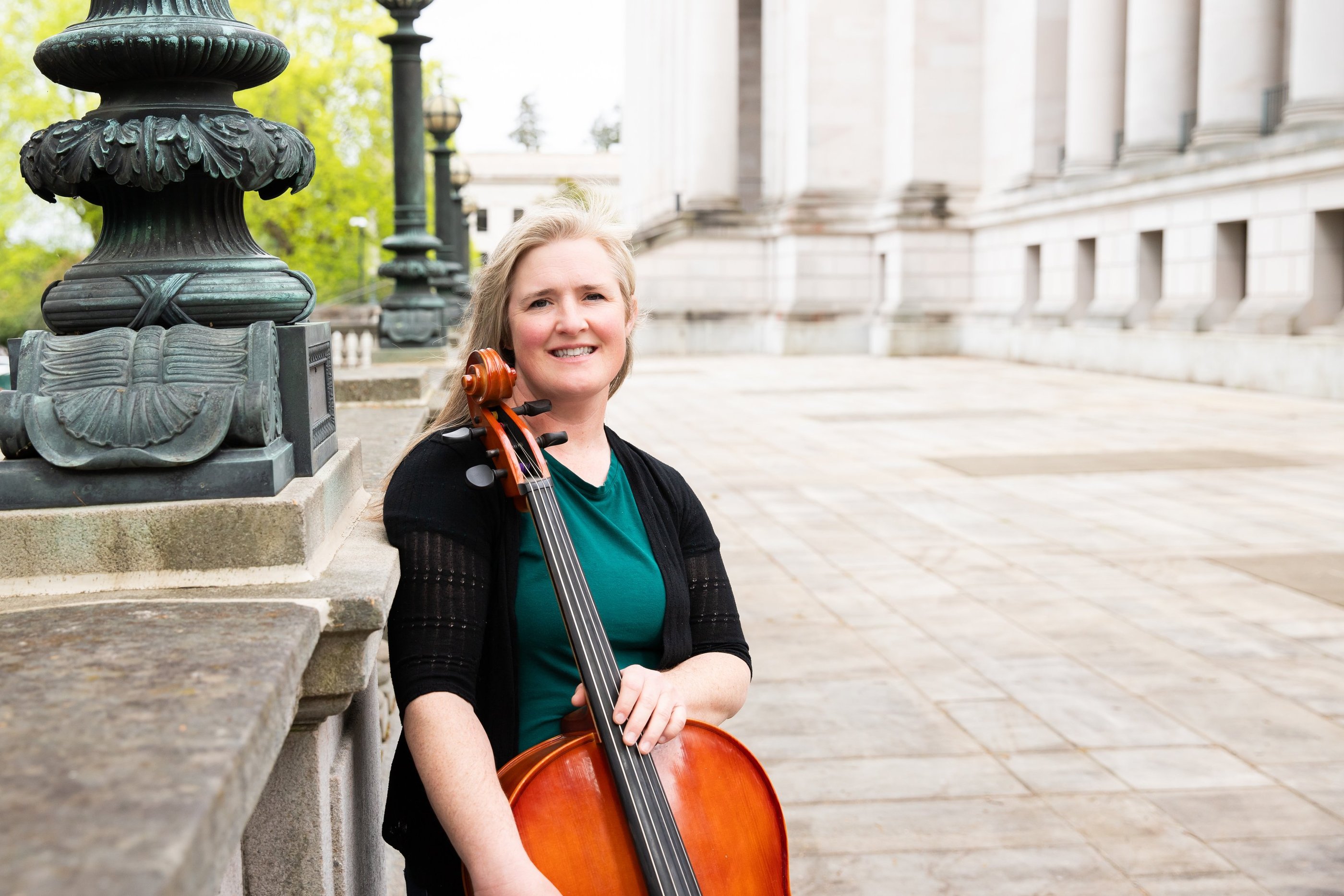 Private lesson teacher holding a cello and smiling