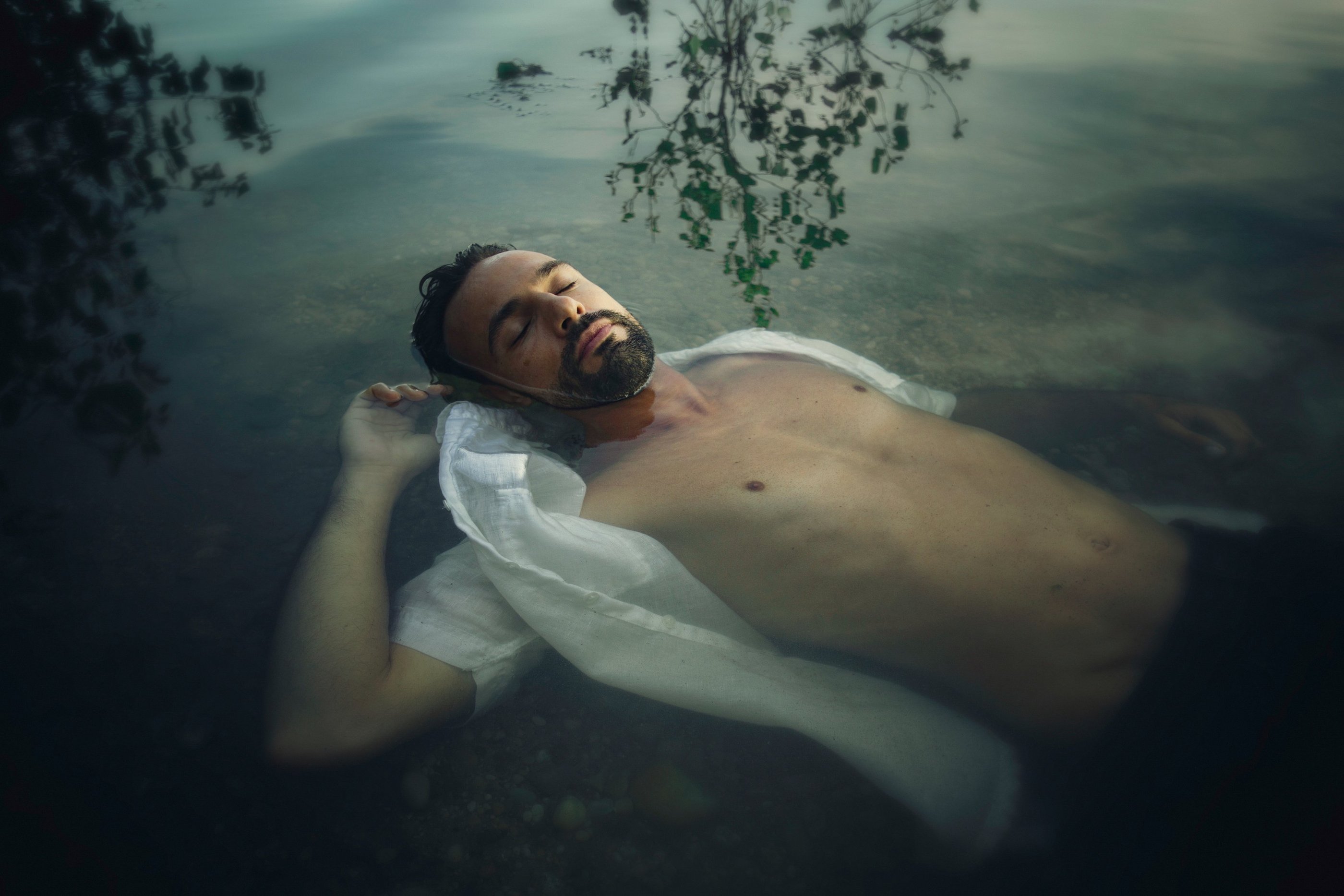 Homme en chemise blanche couché dans l'eau