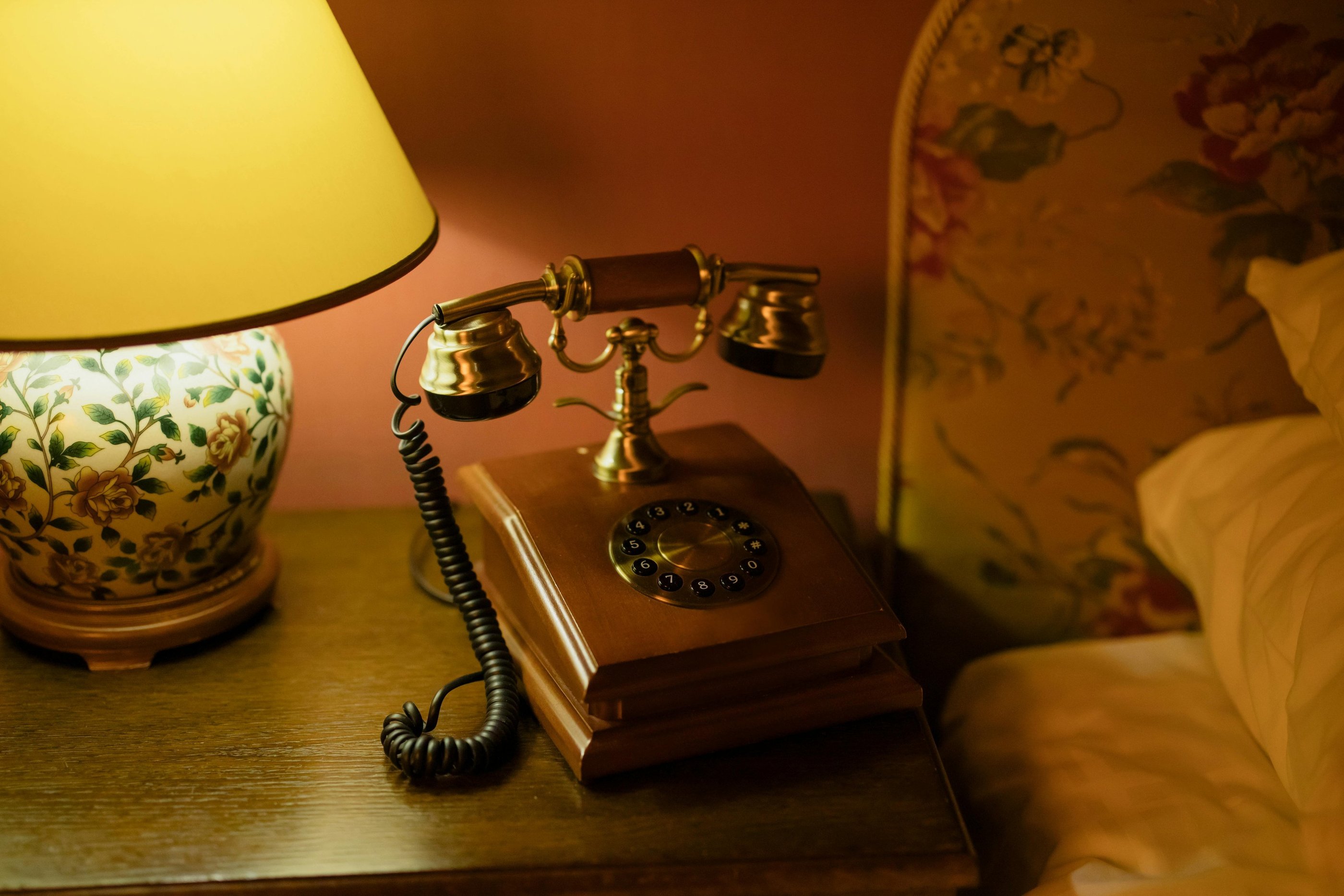 Vintage wood and brass telephone with circle dial and coiled black cable