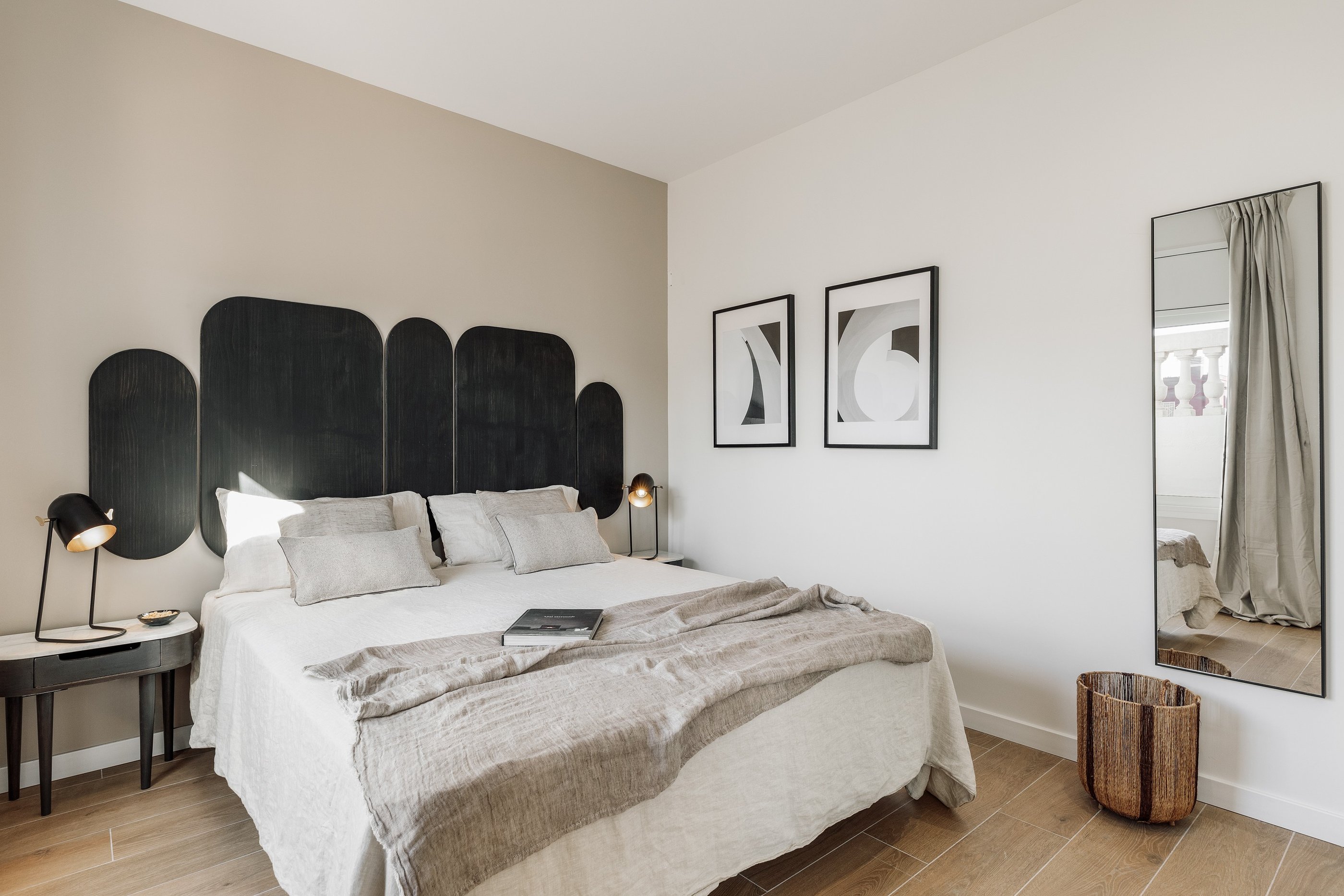 Vibrant bold black wood headboard design in a bedroom with neutral colours and natural materials