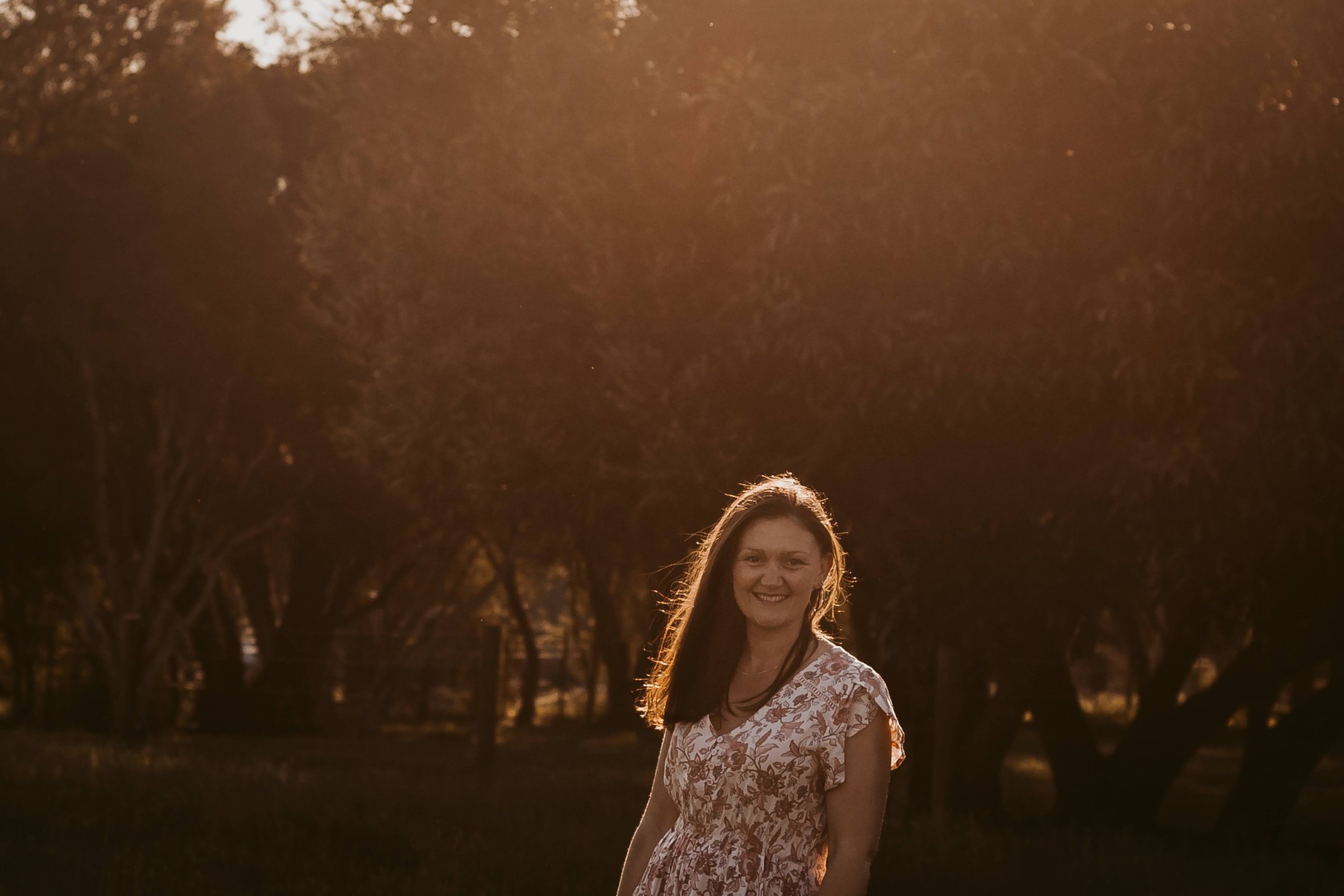 a woman in a dress standing in a field