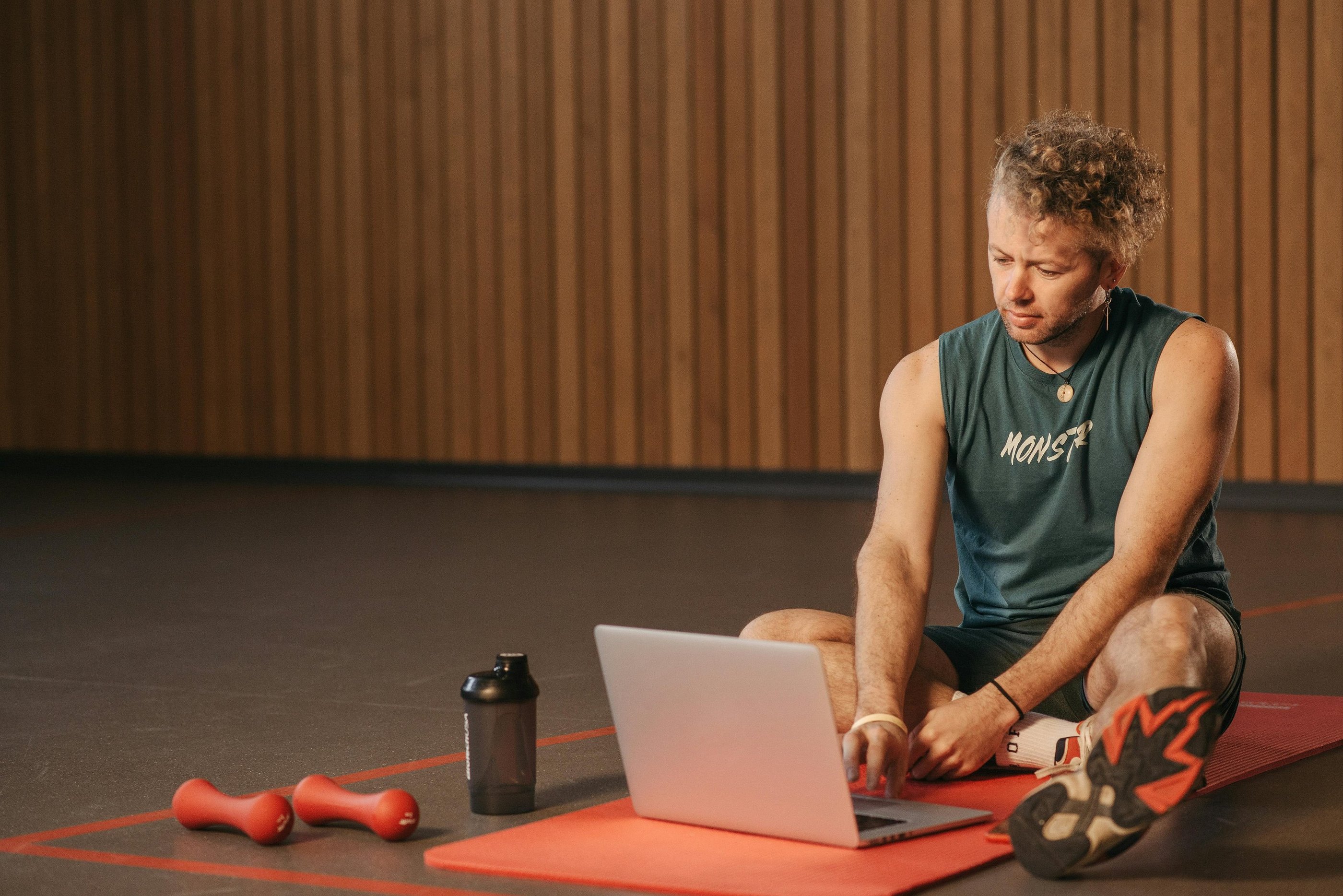 a man sitting on a mat with a laptop