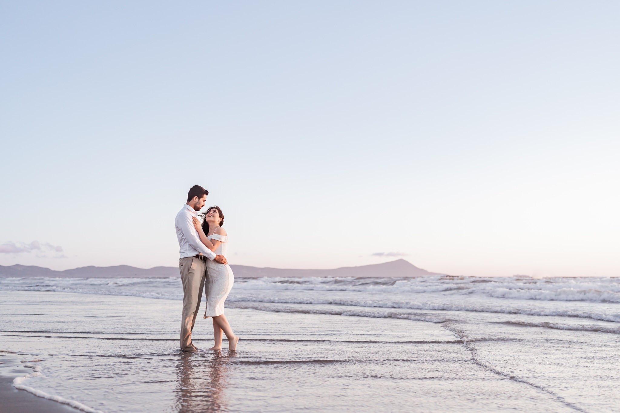 a man and woman standing in the ocean