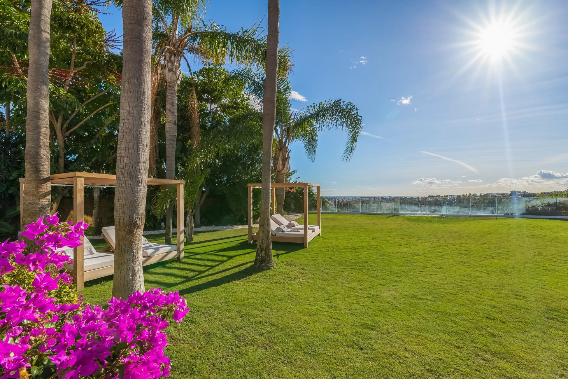 Flat garden lawn with daybeds and panoramic sea views