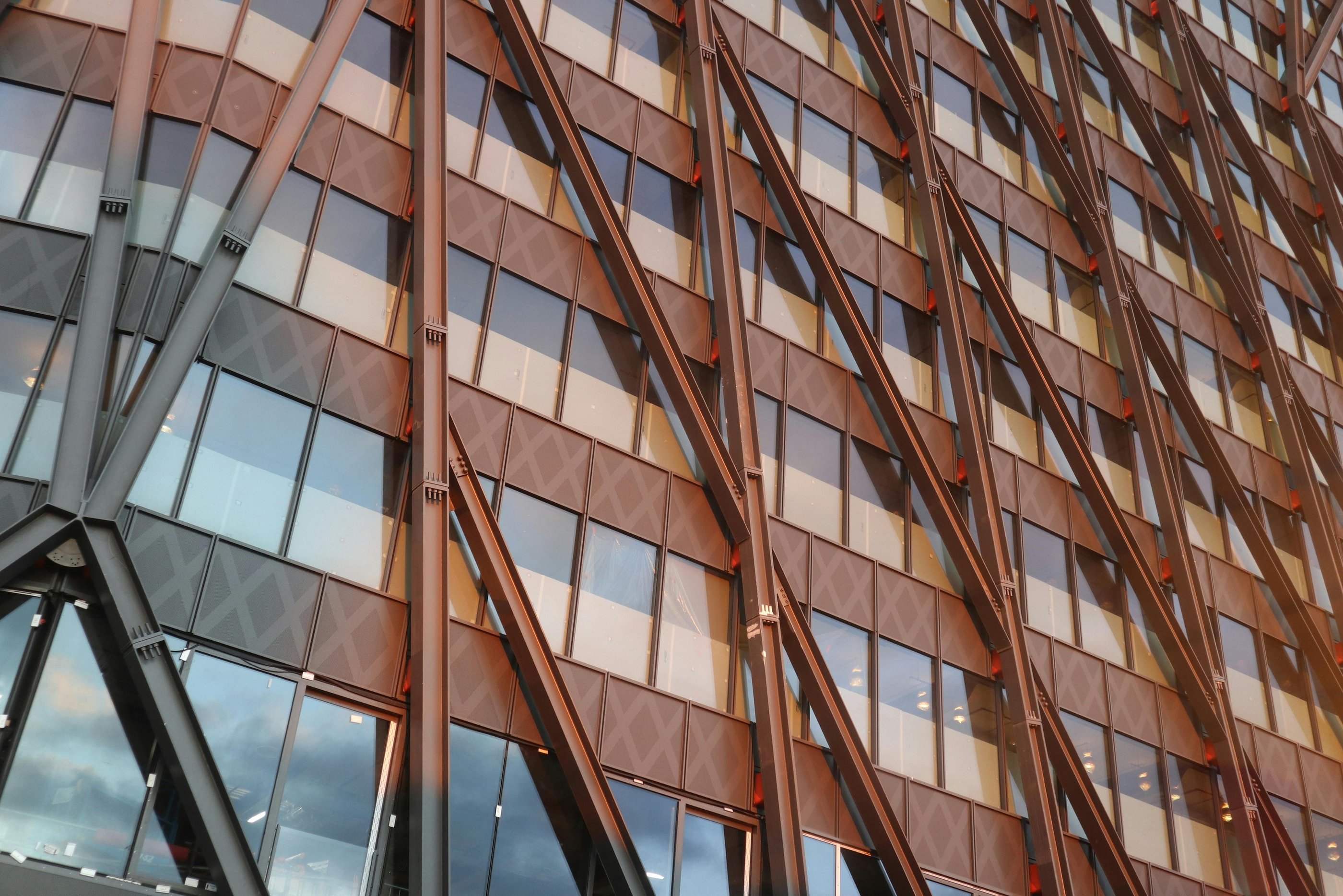 Fachada de edifício moderno com estrutura metálica aparente em diagonal e janelas de vidro
