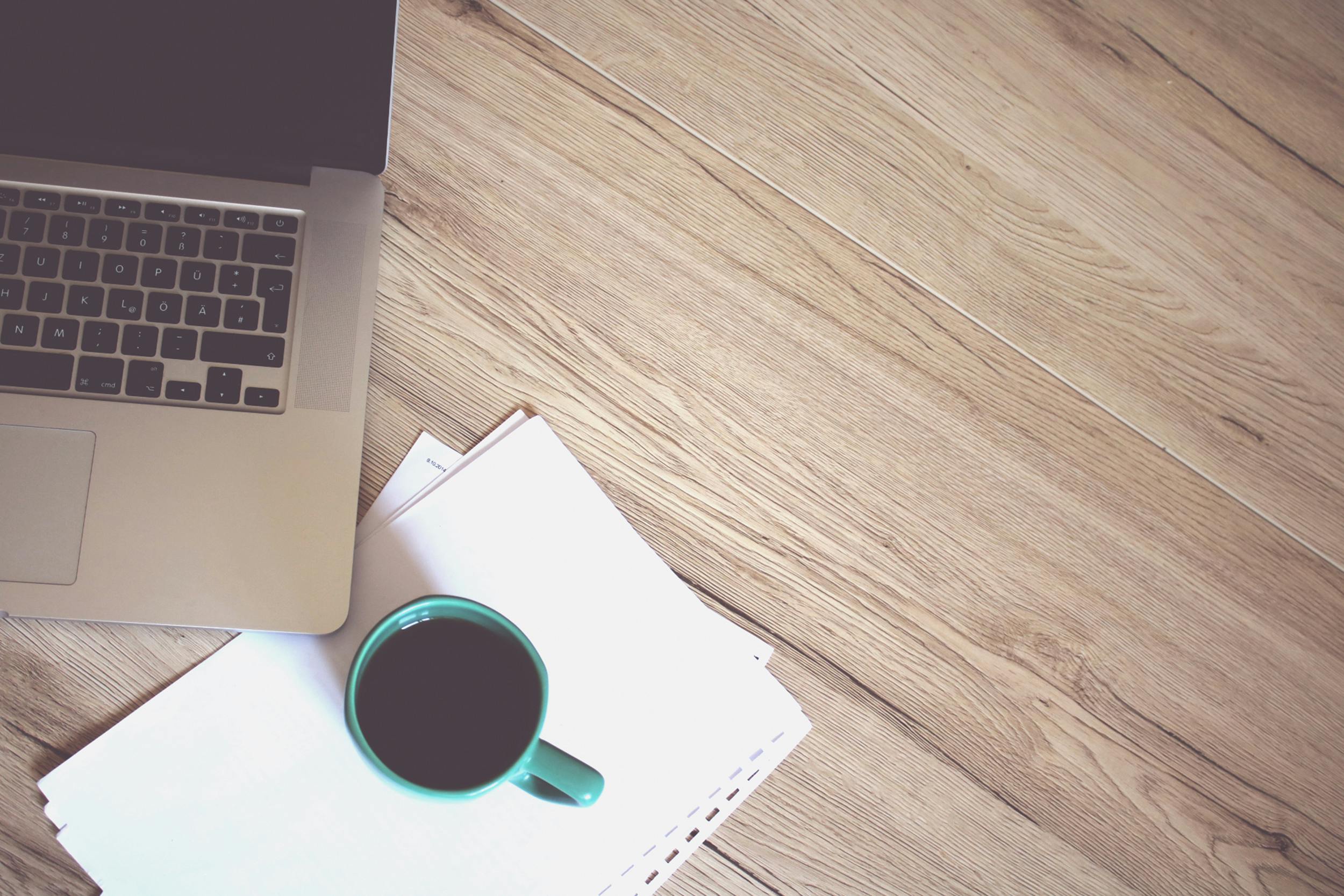 Une tasse de café et un PC sur bureau pour illustrer la page Contact de Kreskin