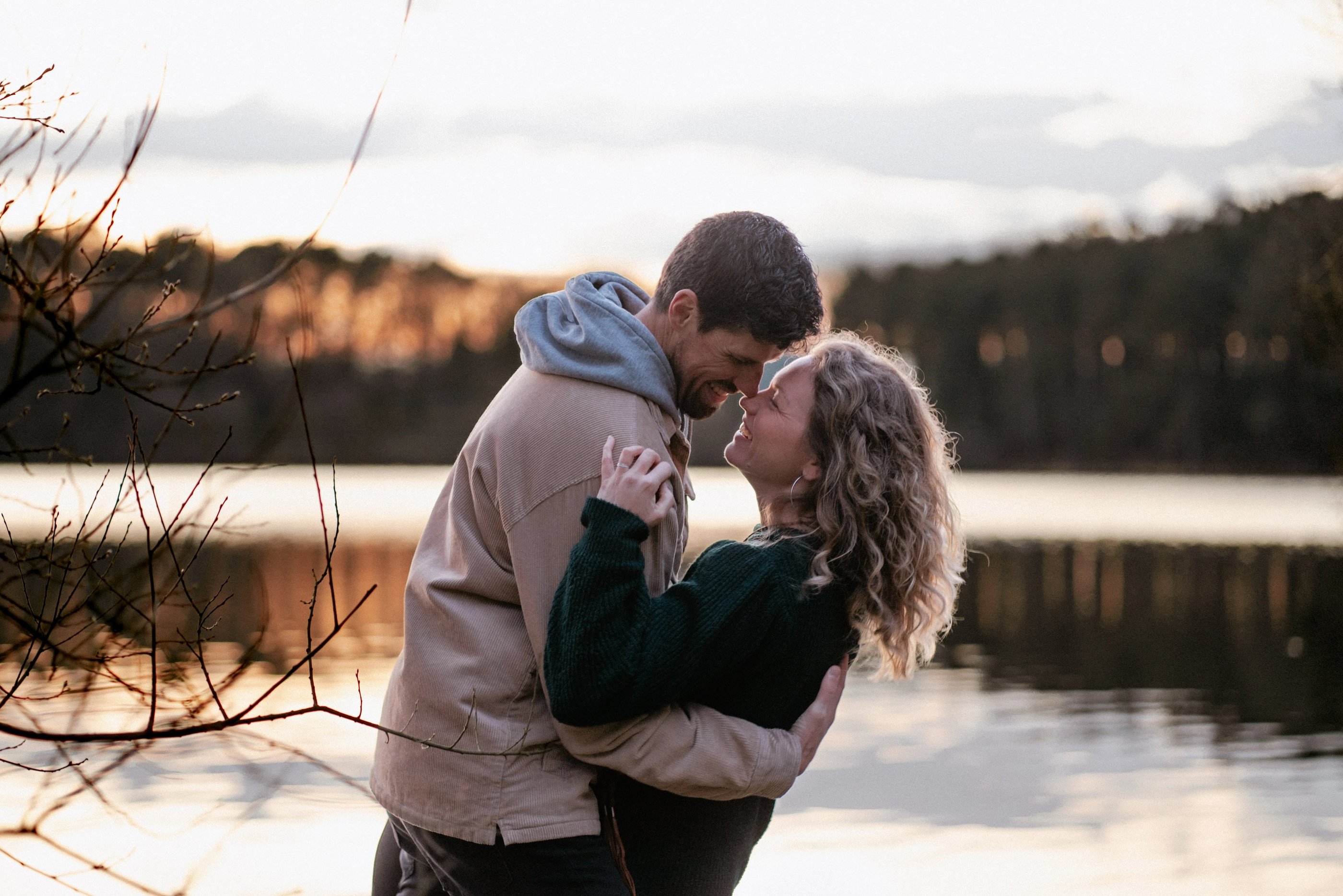 un couple enlacer qui rigole près de l'eau lors d'une séance photo couple à Guignen, à Rennes