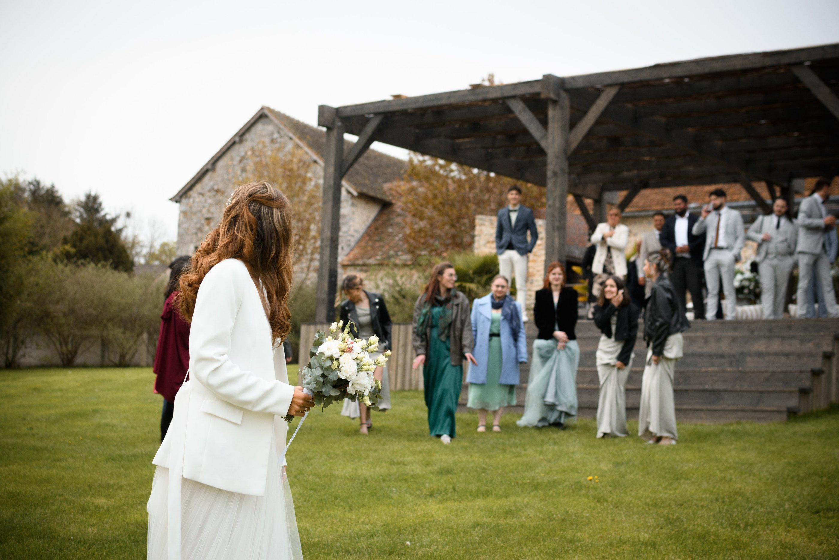 La mariée qui se prépare aux jeté de bouquet. Les témoins et invités se préparent pour l'attraper