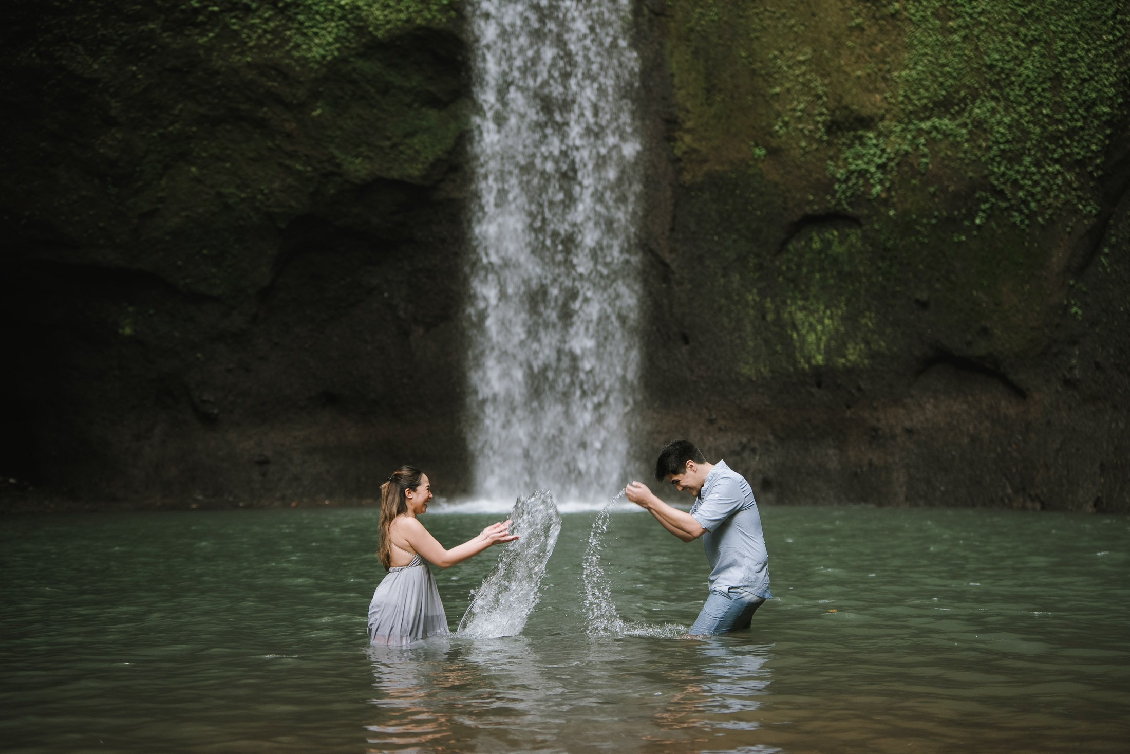 Intimate couple wide shot at Tibumana Waterfall in Bangli Bali