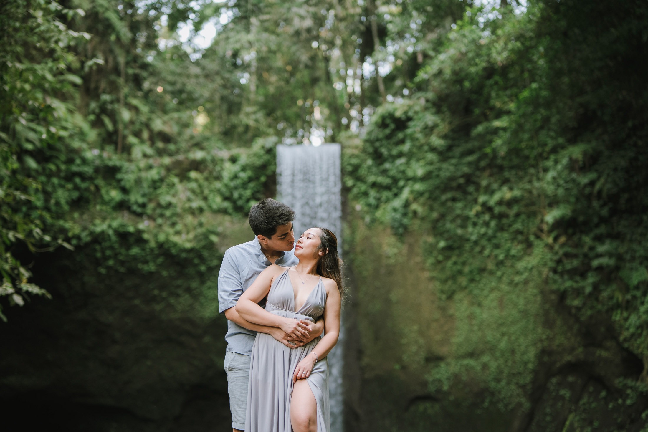 Intimate couple portrait framed by Tibumana Waterfall in Bangli Bali